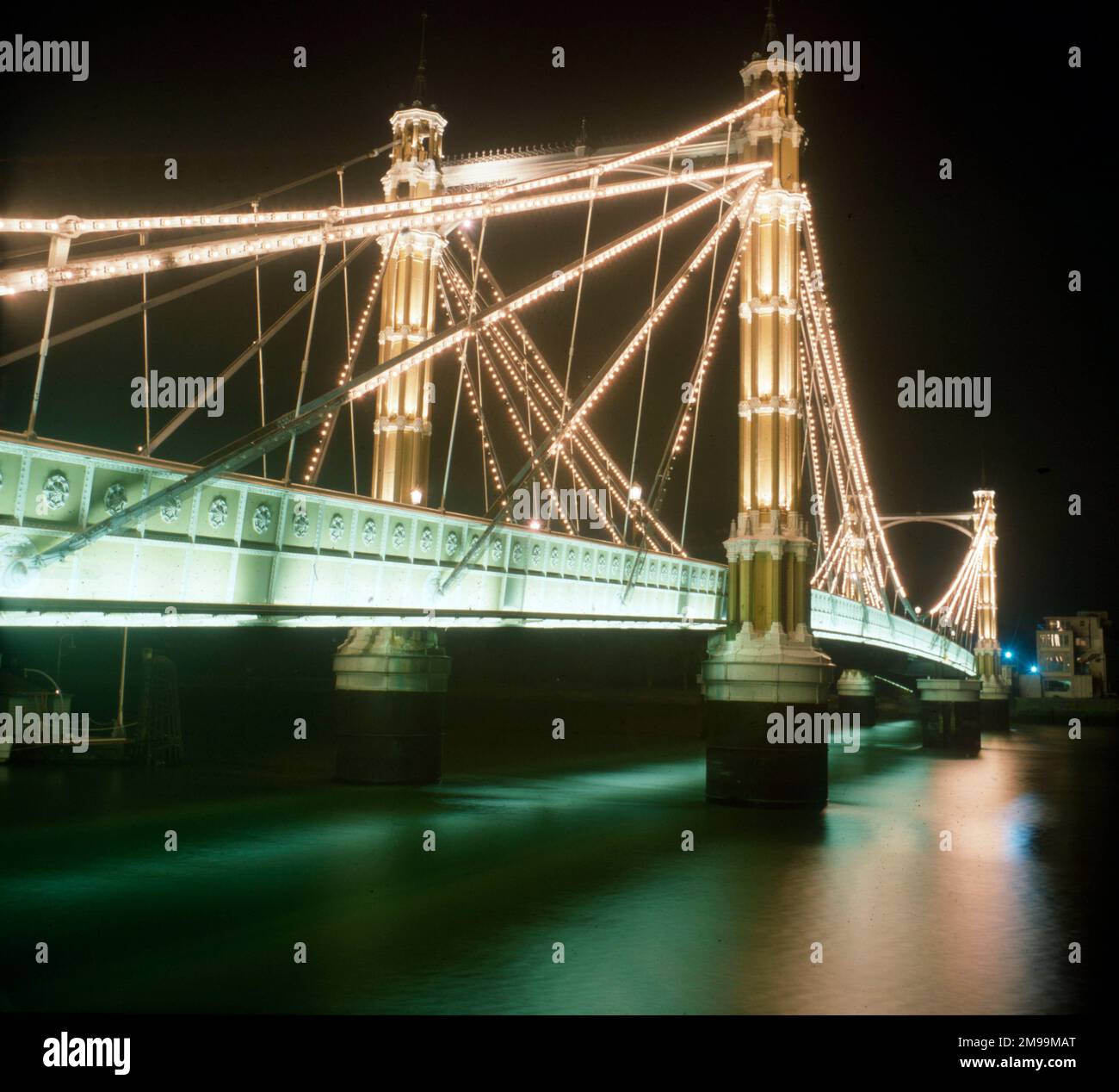 London - The Albert Bridge - illuminated at night. View from Chlesea on the north bank of the River Thames toward Battersea. Designed and built by Rowland Mason Ordish in 1873 as an Ordish–Lefeuvre system modified cable-stayed bridge Stock Photo