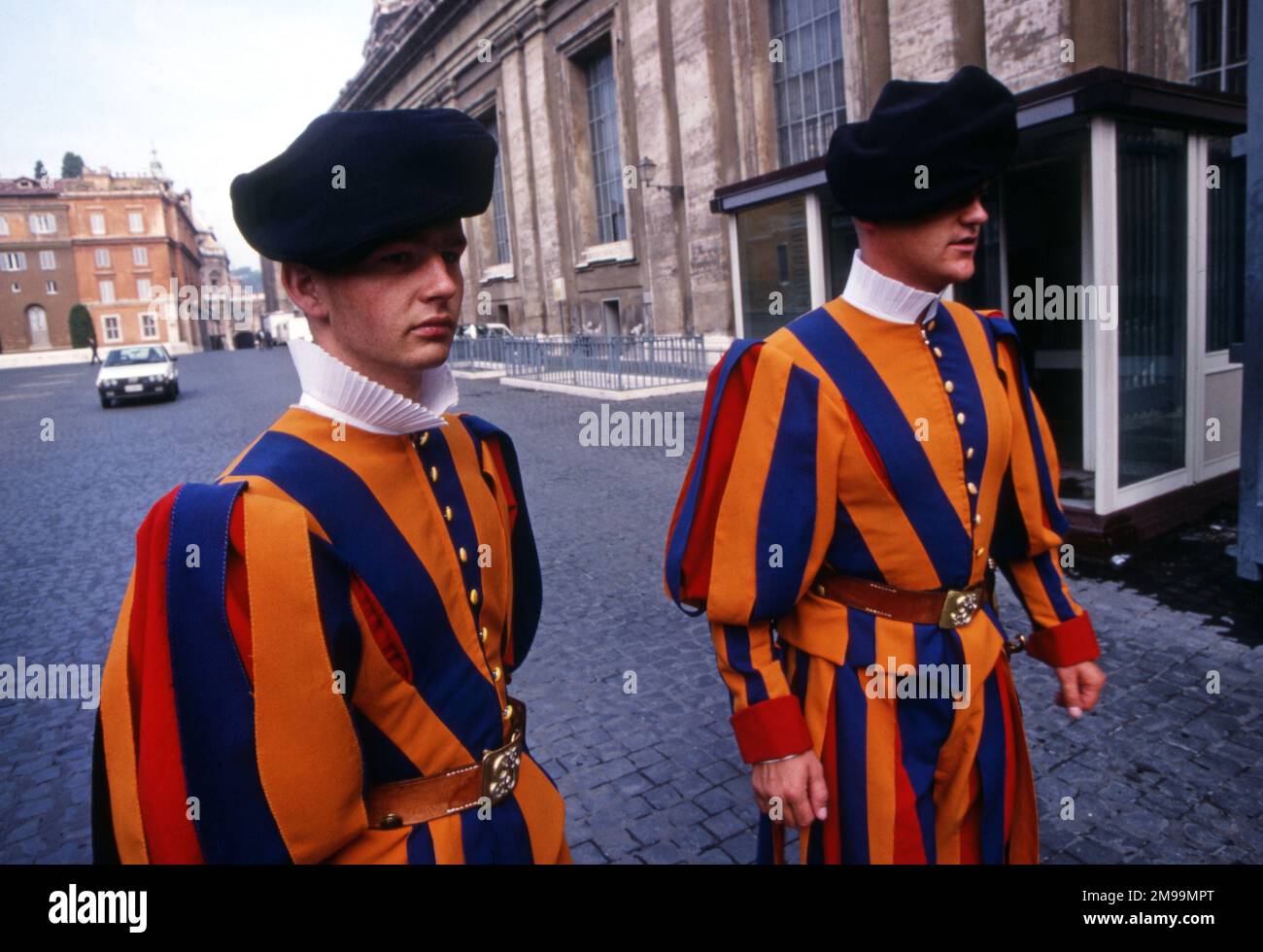 Two Pontifical Swiss Guards stand in Vatican City in Rome, Italy. They wear colorful Renaissance-era uniforms of blue, yellow and red Stock Photo