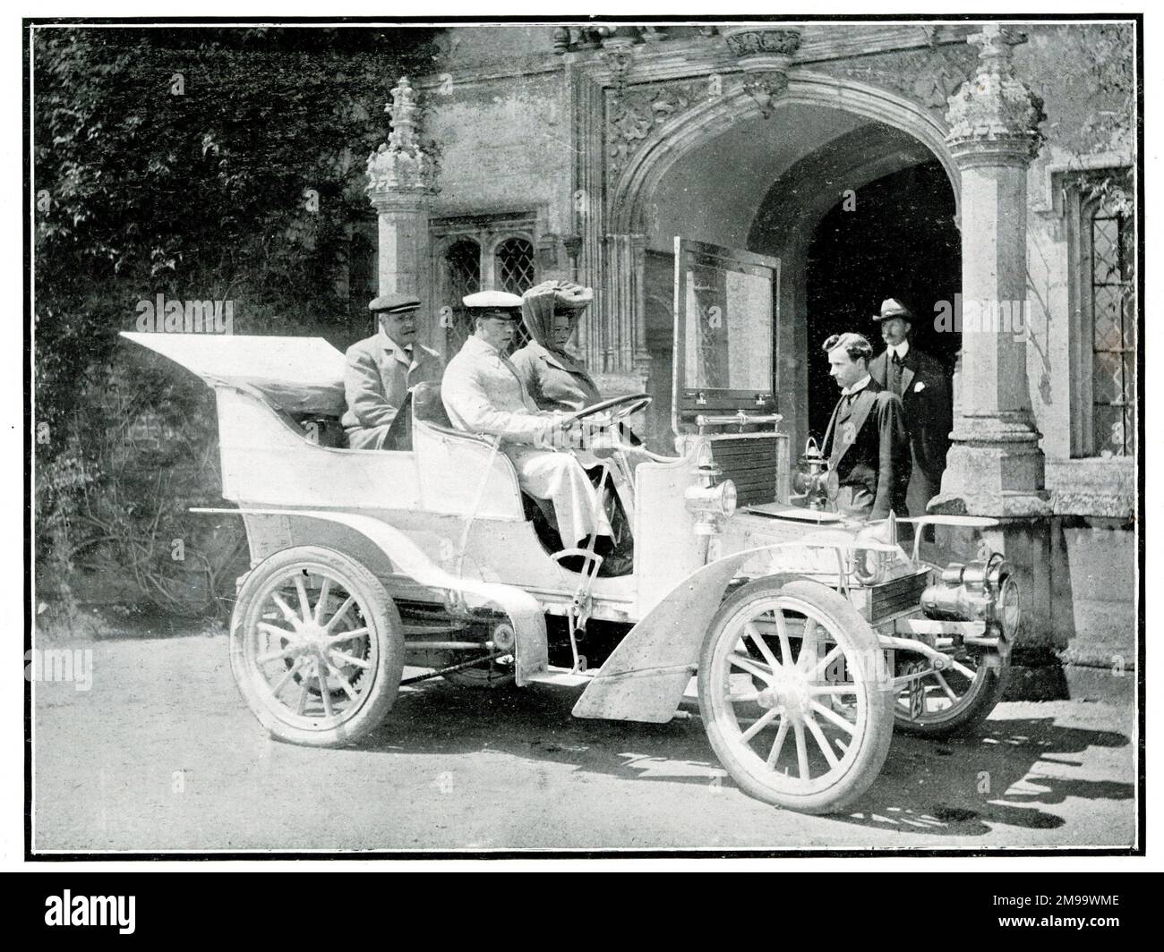 Three Edwardian people in a veteran car -- Mr and Hon Mrs Wood, with Captain Hutchinson of the 21st Lancers, outside Hengrave Hall, near Bury St Edmunds, Suffolk, September 1906. Stock Photo