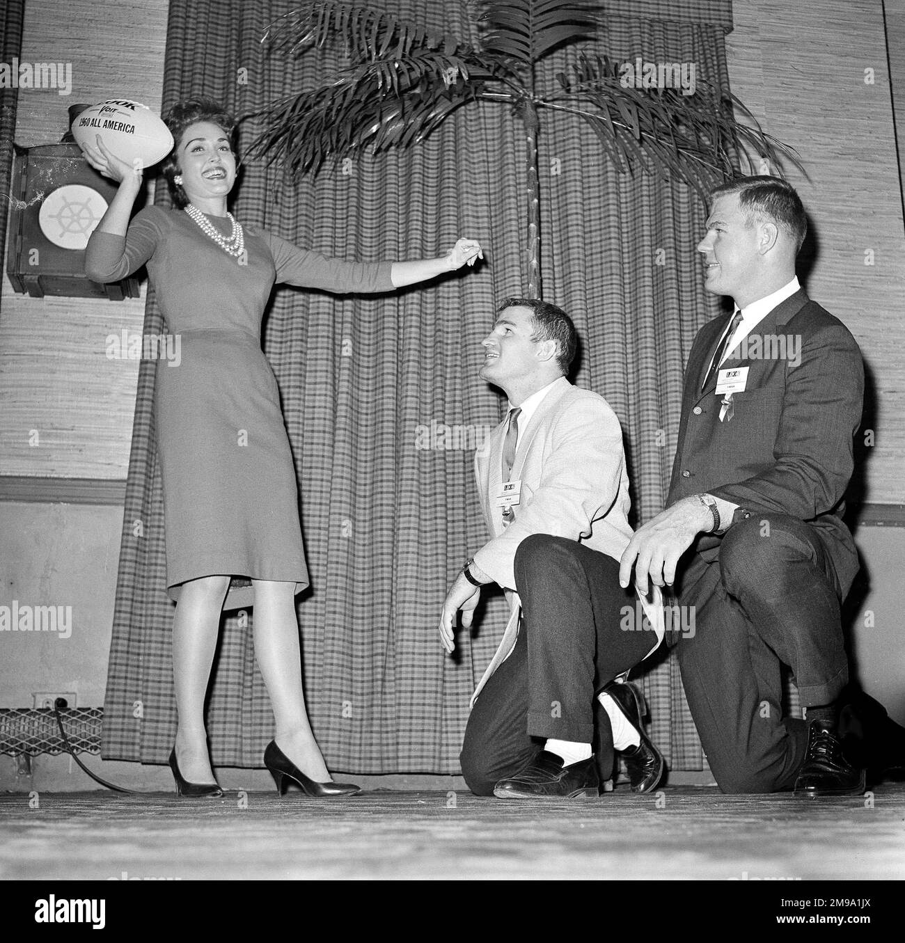 Pat Finn, Orange Bowl queen, shows her technique with a football to Joe