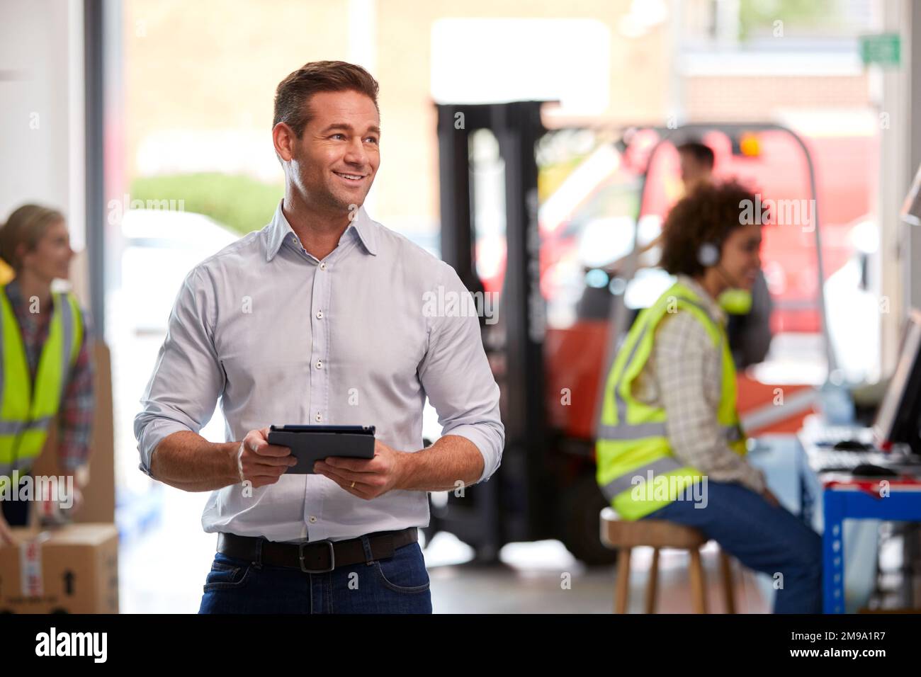 Male Manager In Logistics Distribution Warehouse Using Digital Tablet Stock Photo