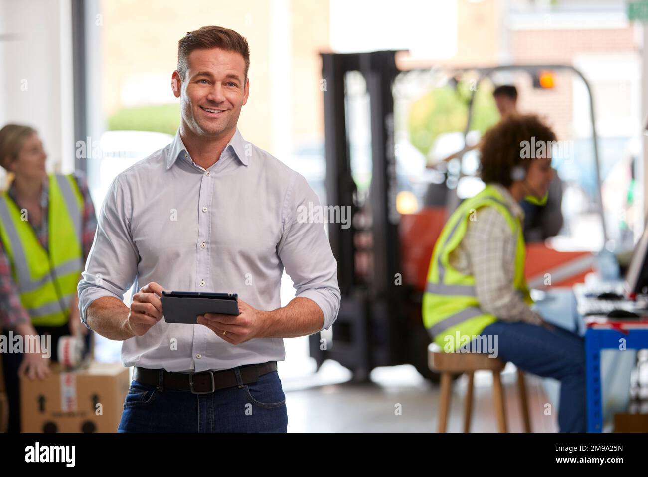 Male Manager In Logistics Distribution Warehouse Using Digital Tablet Stock Photo