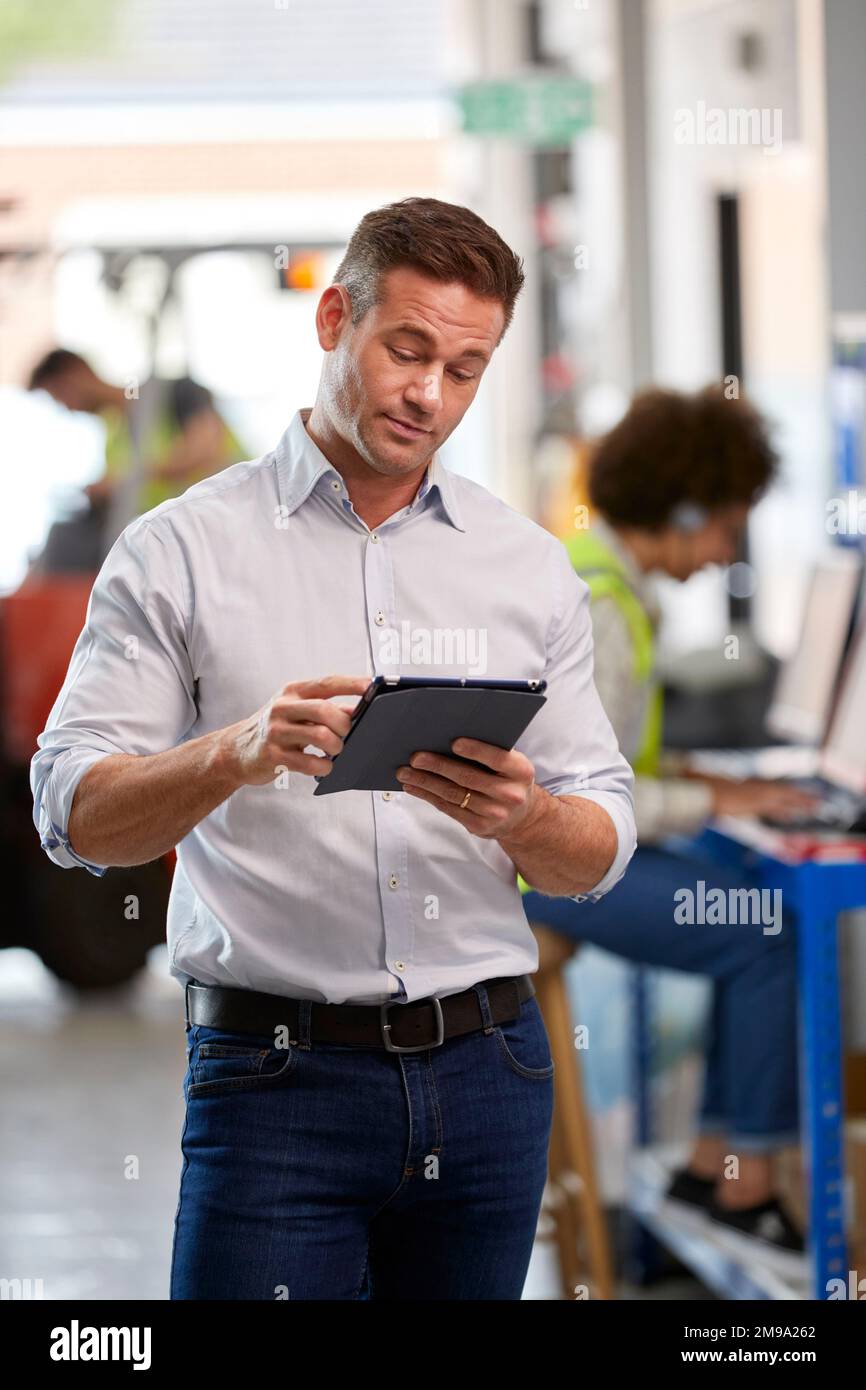 Male Manager In Logistics Distribution Warehouse Using Digital Tablet Stock Photo
