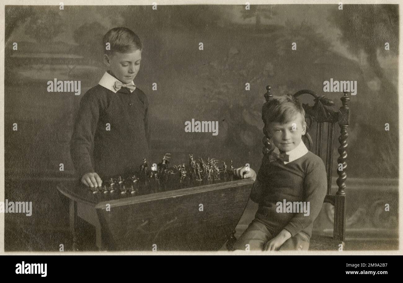 Two smart young boys (in matching bowties!) play with their model soldiers in this studio shoot. Stock Photo