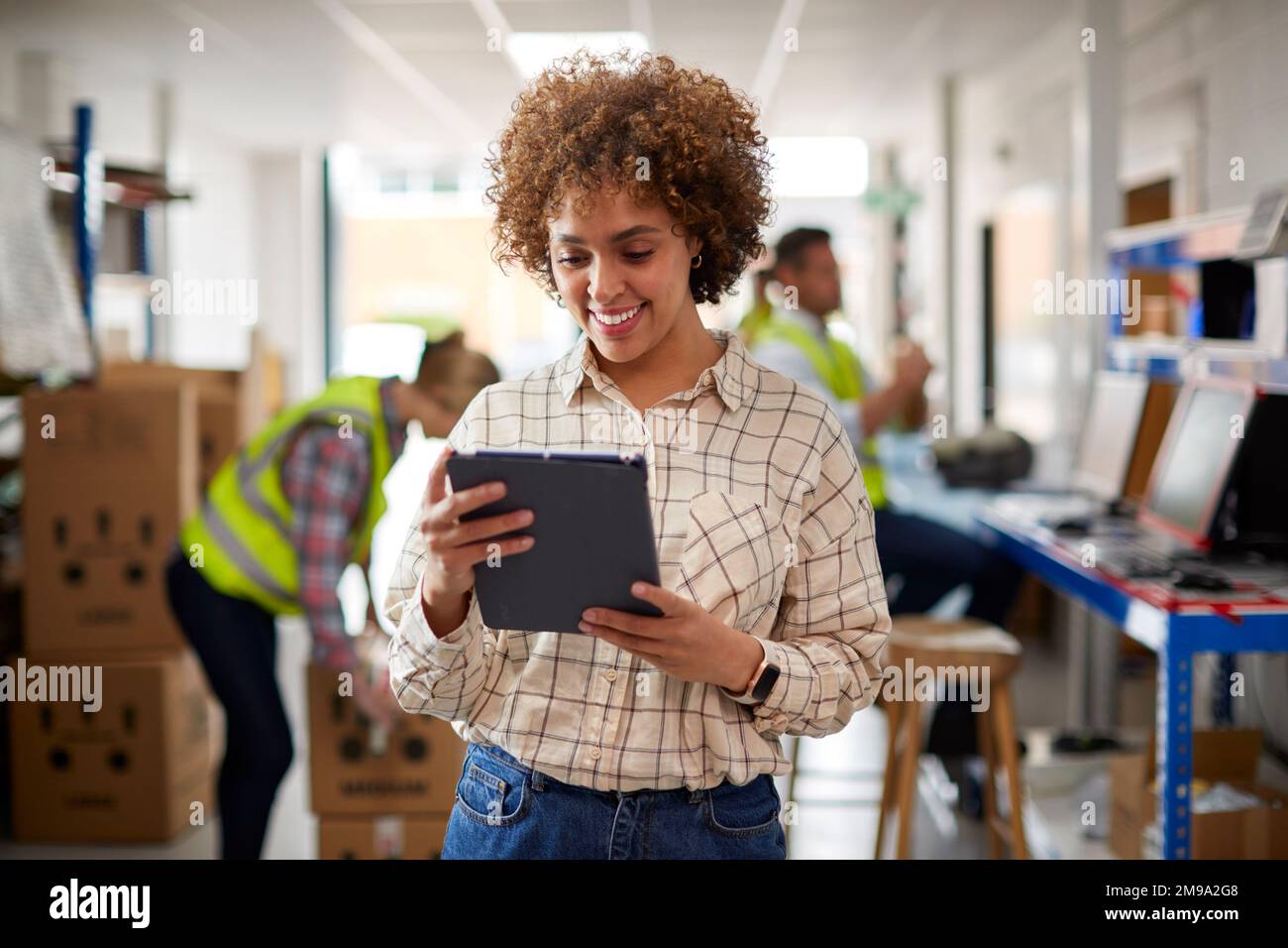 Female Manager In Logistics Distribution Warehouse Using Digital Tablet Stock Photo