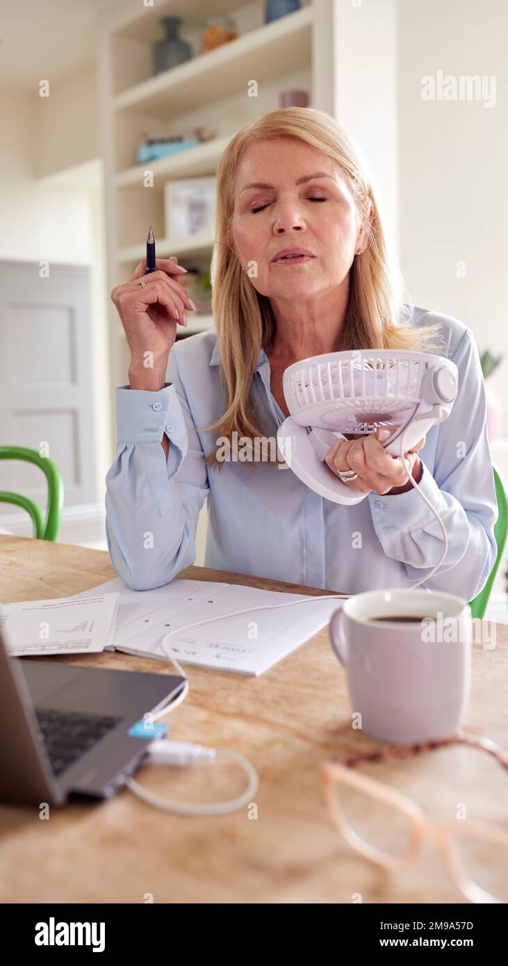 Menopausal Mature Woman Having Hot Flush At Home Cooling Herself With
