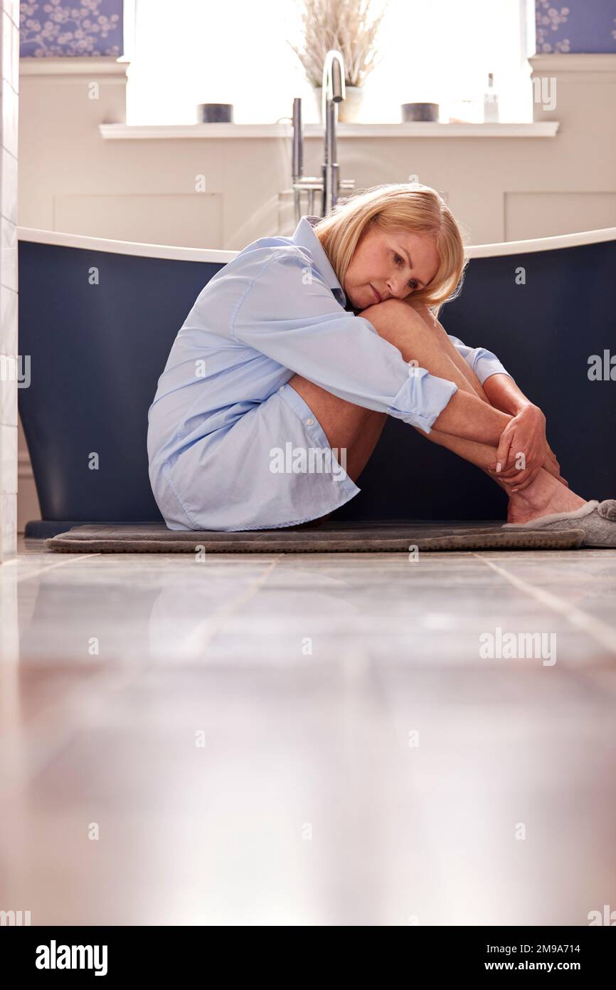 Menopausal Mature Woman Suffering With Incontinence Sitting On Bathroom