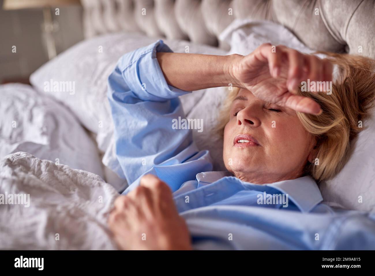 Menopausal Mature Woman Suffering With Insomnia In Bed At Home Stock Photo