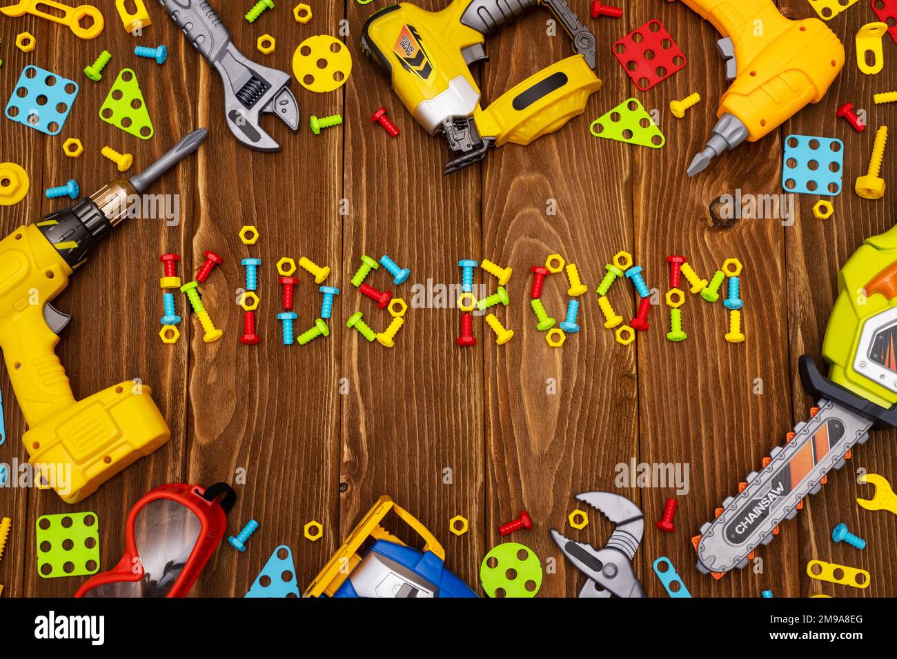 Colorful toy tools as frame with text Kids Room on wooden background Stock Photo