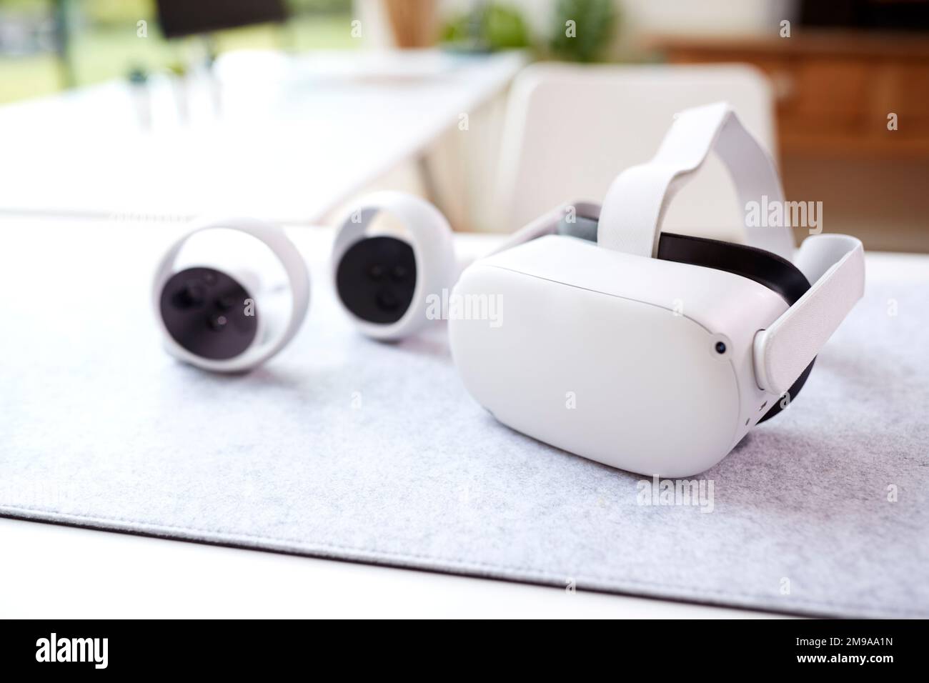 VR Headset And Gaming Controllers On Table At Home Stock Photo