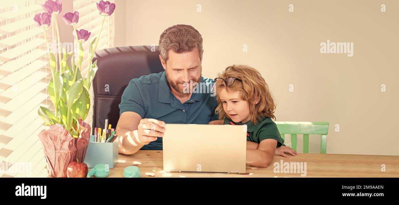 Banner of home school of father and son with laptop at home, bearded dad or school private tutor teaching boy son with modern laptop, school Stock Photo