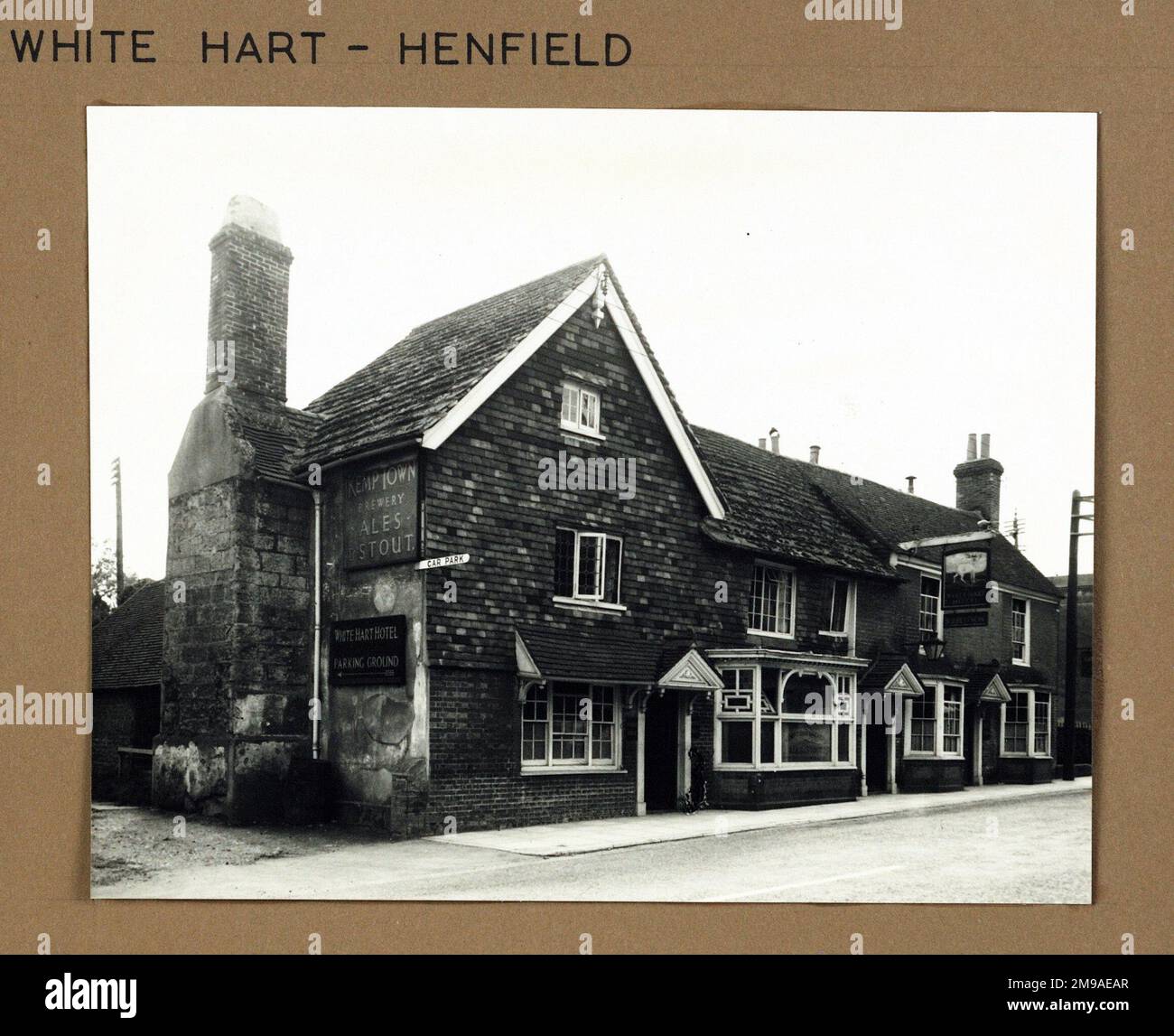 Photograph of White Hart Hotel, Henfield, Sussex. The main side of the print (shown here) depicts: Left Face on view of the pub.  The back of the print (available on request) details: Nothing for the White Hart Hotel, Henfield, Sussex BN5 9HP. As of July 2018 . Hall & Woodhouse Stock Photo