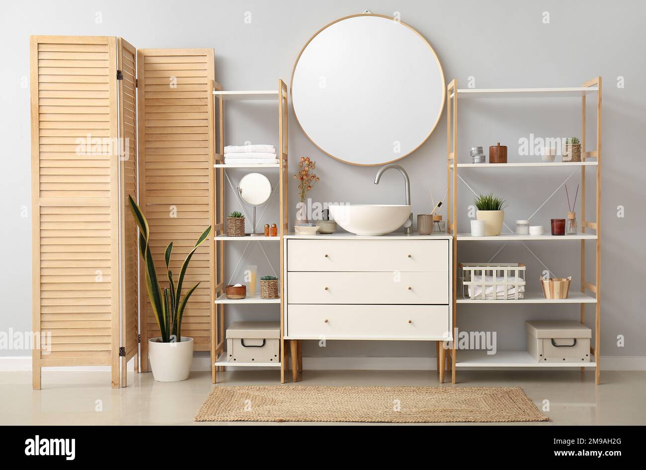 Interior of bathroom with ceramic sink, drawers and shelving units ...