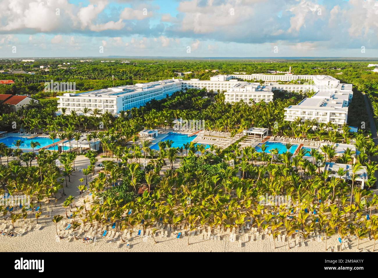 Aerial view of tropical resort Punta Cana. Luxury vacation resort with white sand beach and upscale pool area, tall palms, idyllic seaside hotel in Punta Cana, Dominican Republic, aerial view. Stock Photo