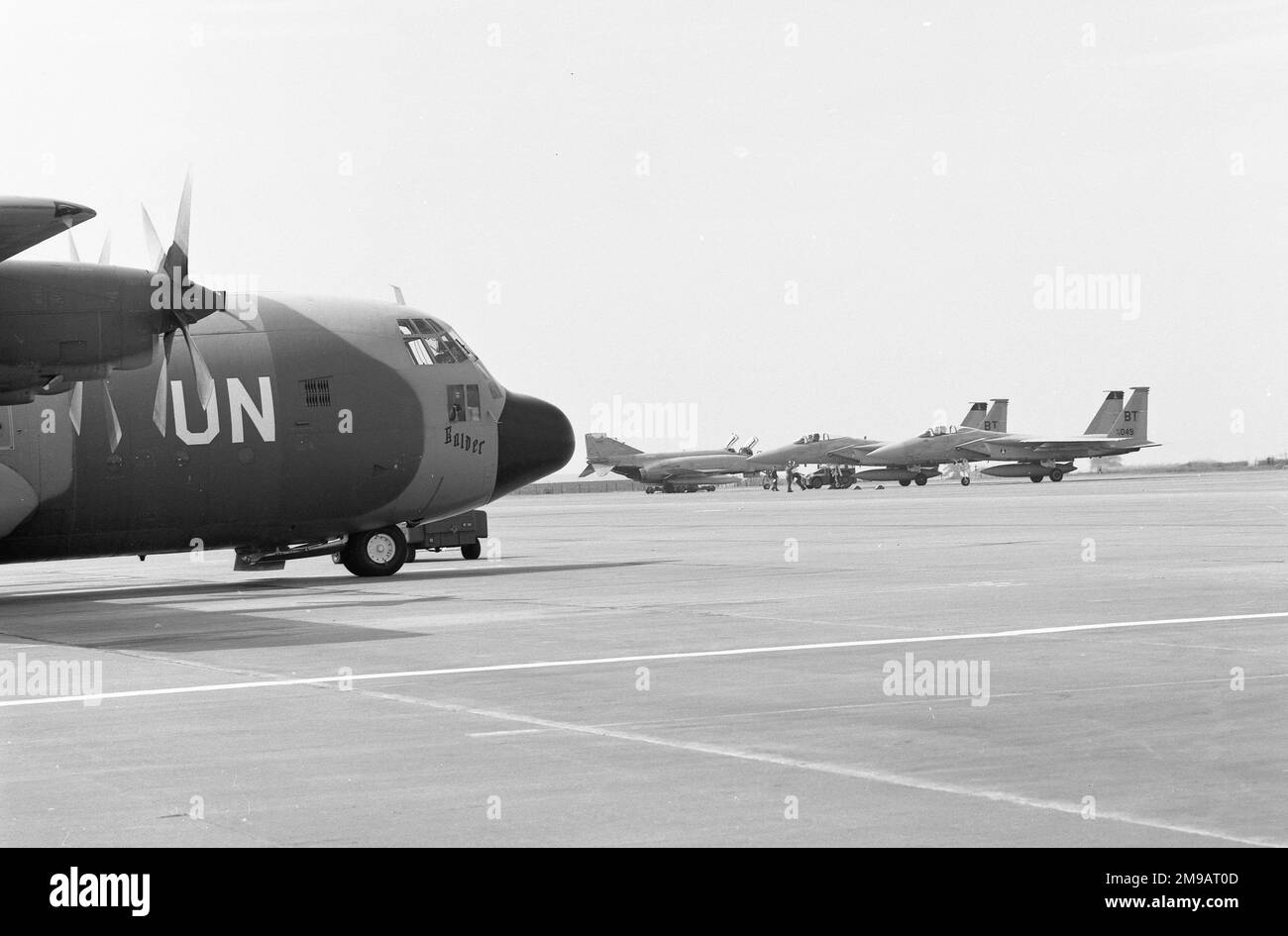 Royal Norwegian Air Force / United Nations - Lockheed C-130H Hercules 954 'Balder', being loaded at RAF Wattisham for a mission supporting the United Nations in 1984. With an RAF Phantom FGR.2 and some visiting United States Air Force F-15 Eagles, from Bitburg Air Force Base in Germany. Stock Photo