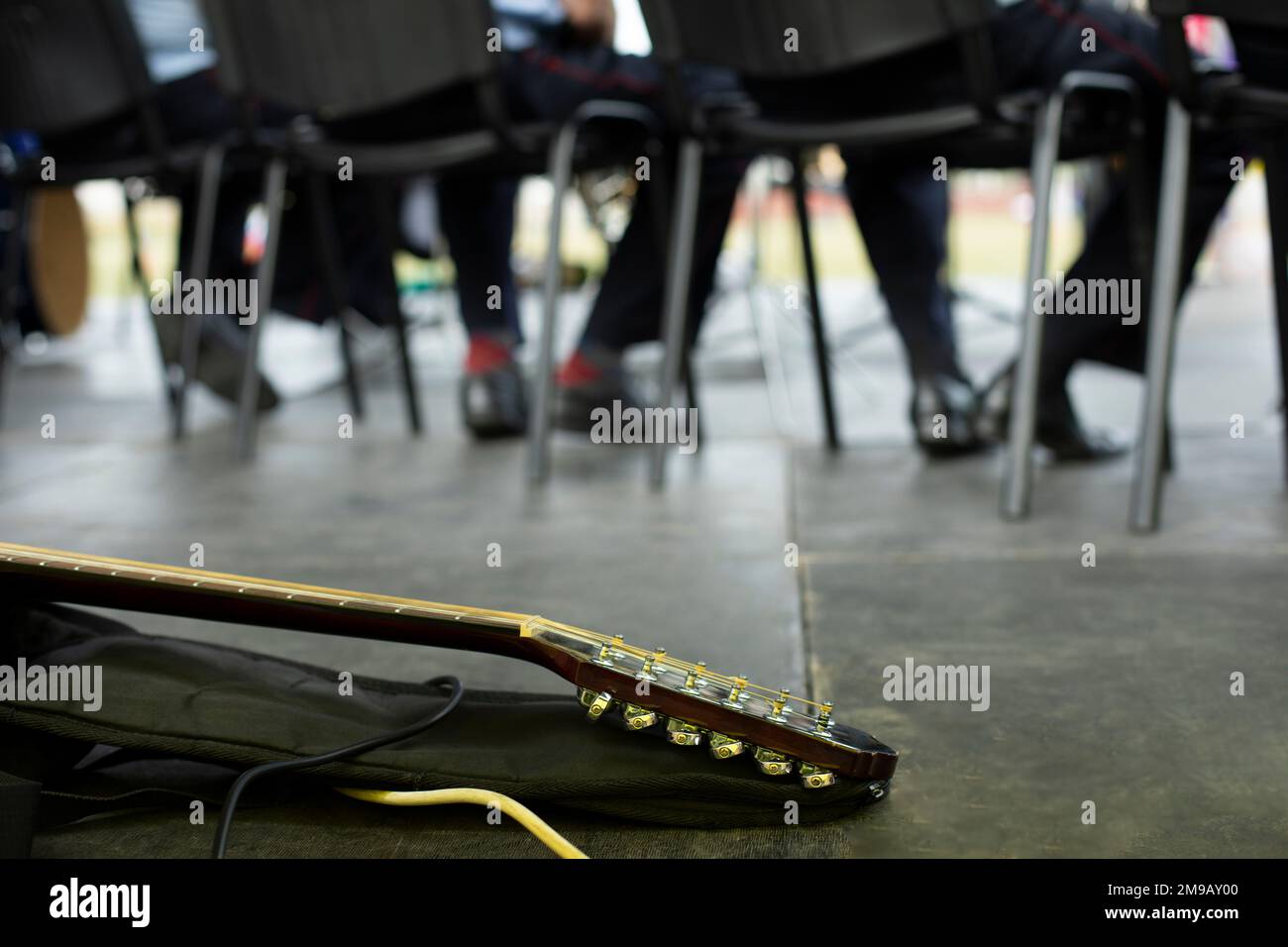 Guitar on stage. Musical instrument at performance. Guitar neck and case. Details of concert. Stock Photo