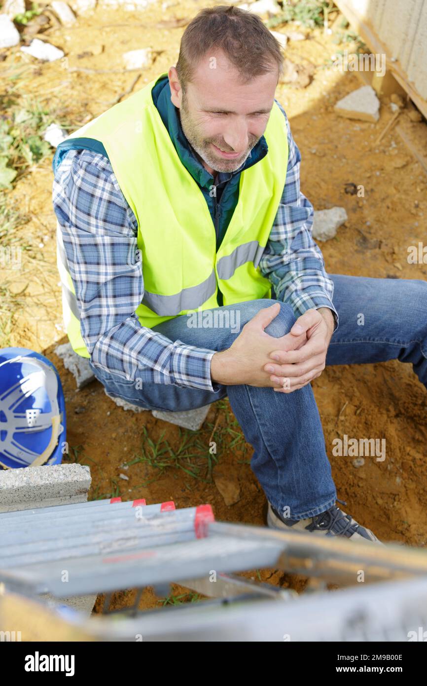 injured architect on the ground after falling off a ladder Stock Photo