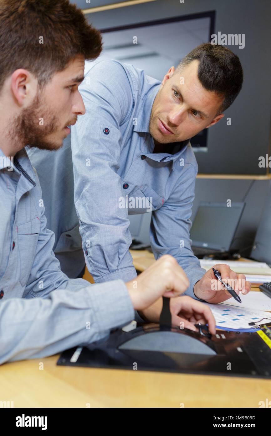 two men in the office with checklist Stock Photo