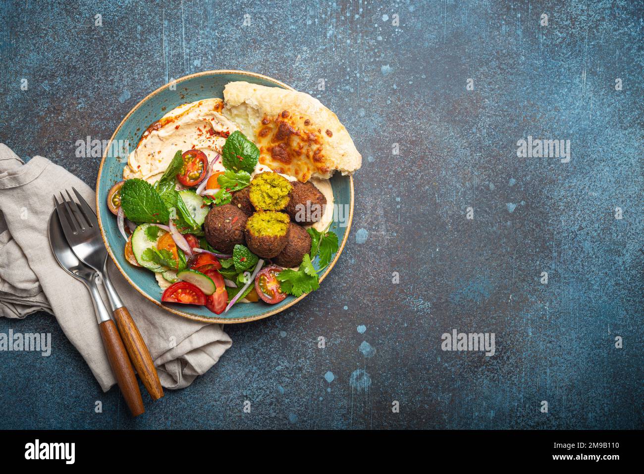 Middle Eastern Arab meal with fried falafel, hummus, vegetables salad, pita bread Stock Photo
