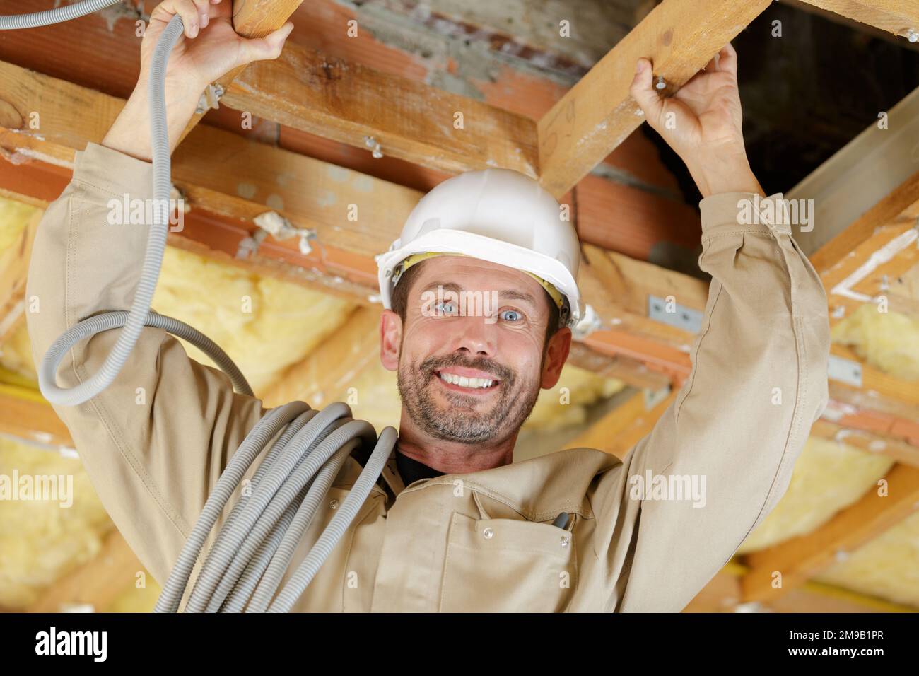 electrician installing ventilation in ceiling Stock Photo