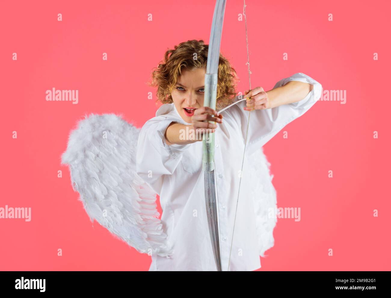 Arrows of love. Female angel in angelic wings shooting with bow. Valentines day cupid. Love concept. Stock Photo