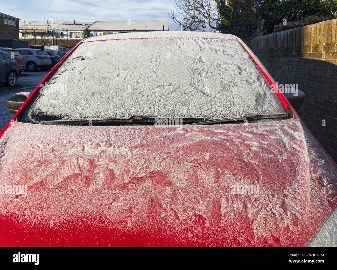 Motor car covered in a hard frost with frost patterns on bonnet and window Stock Photo