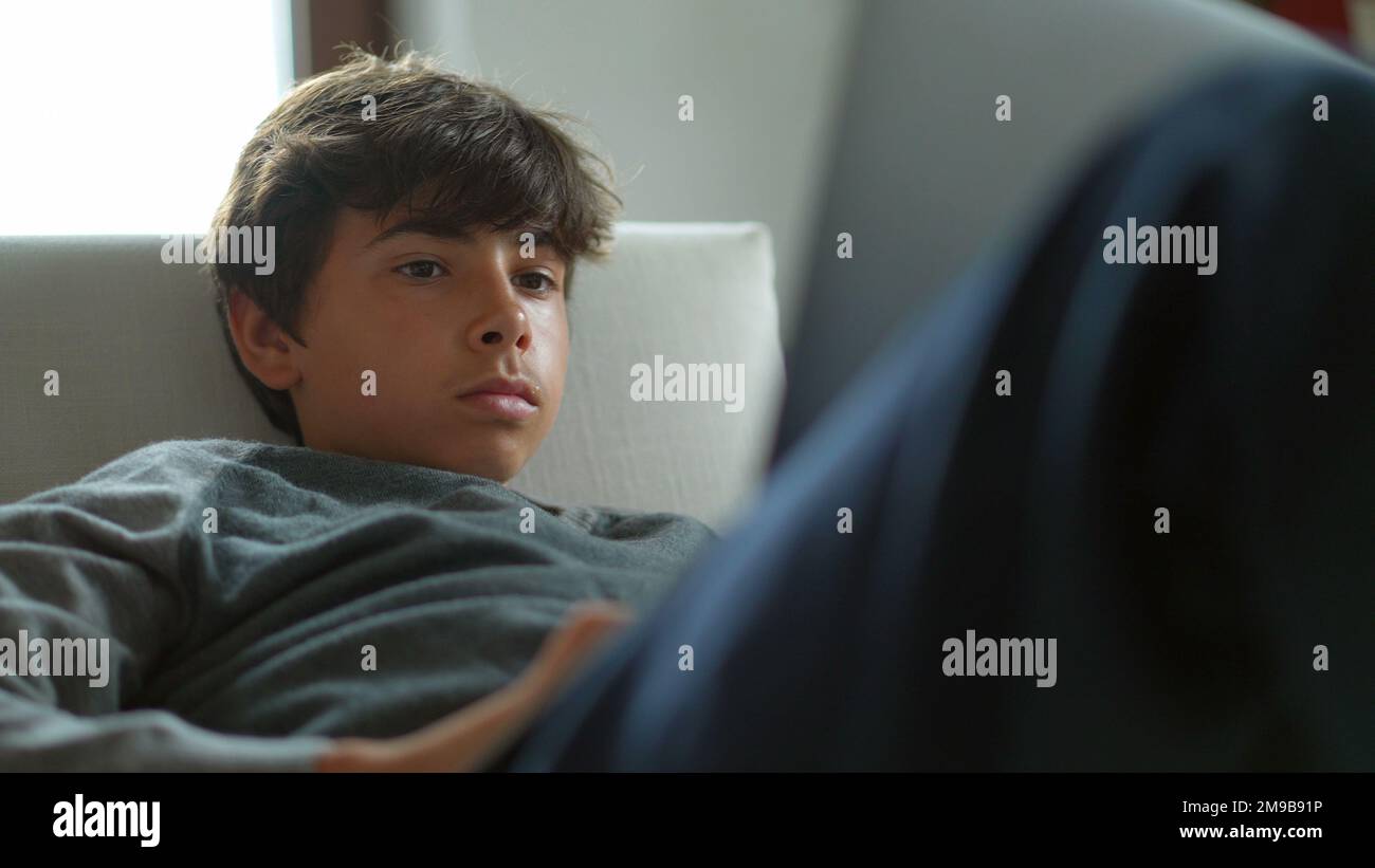 Young boy using laptop at home. Kid staring at computer screen sitting ...