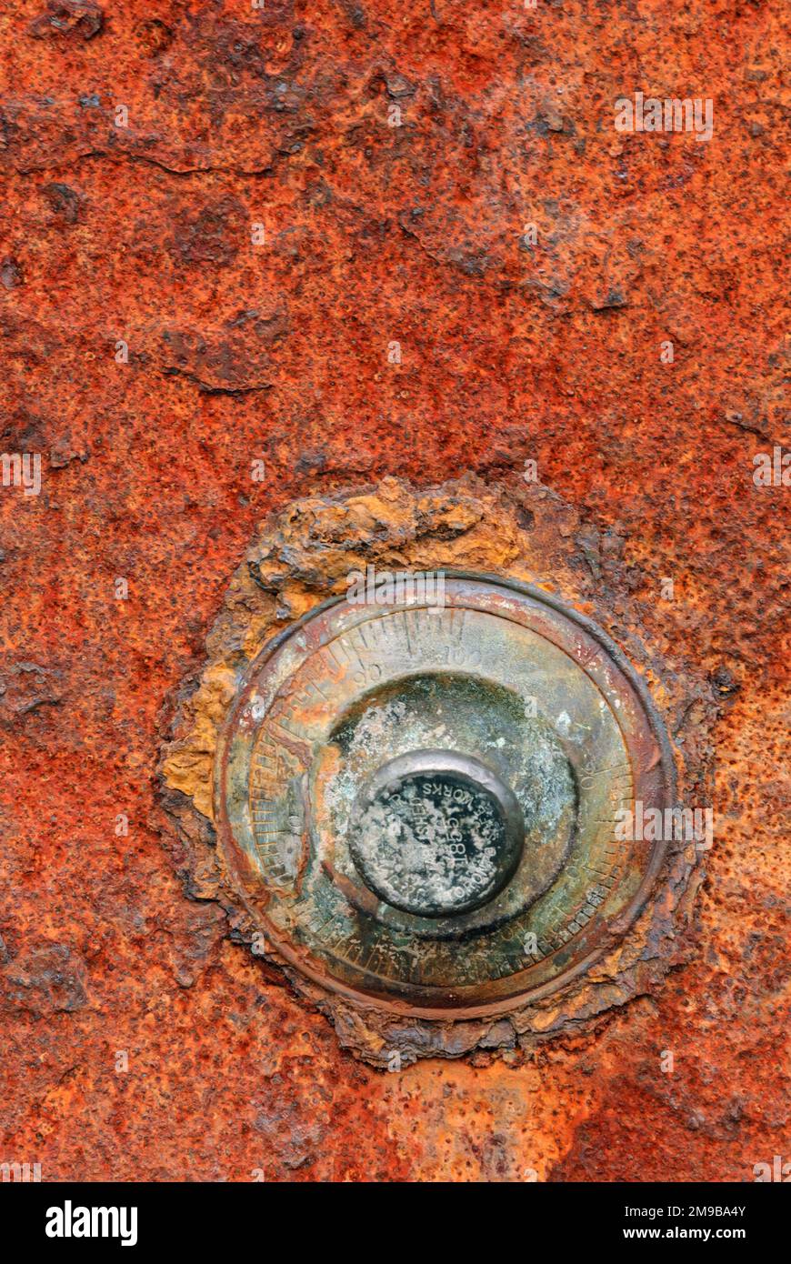 Rusted combination lock on a red rusty safe door Stock Photo