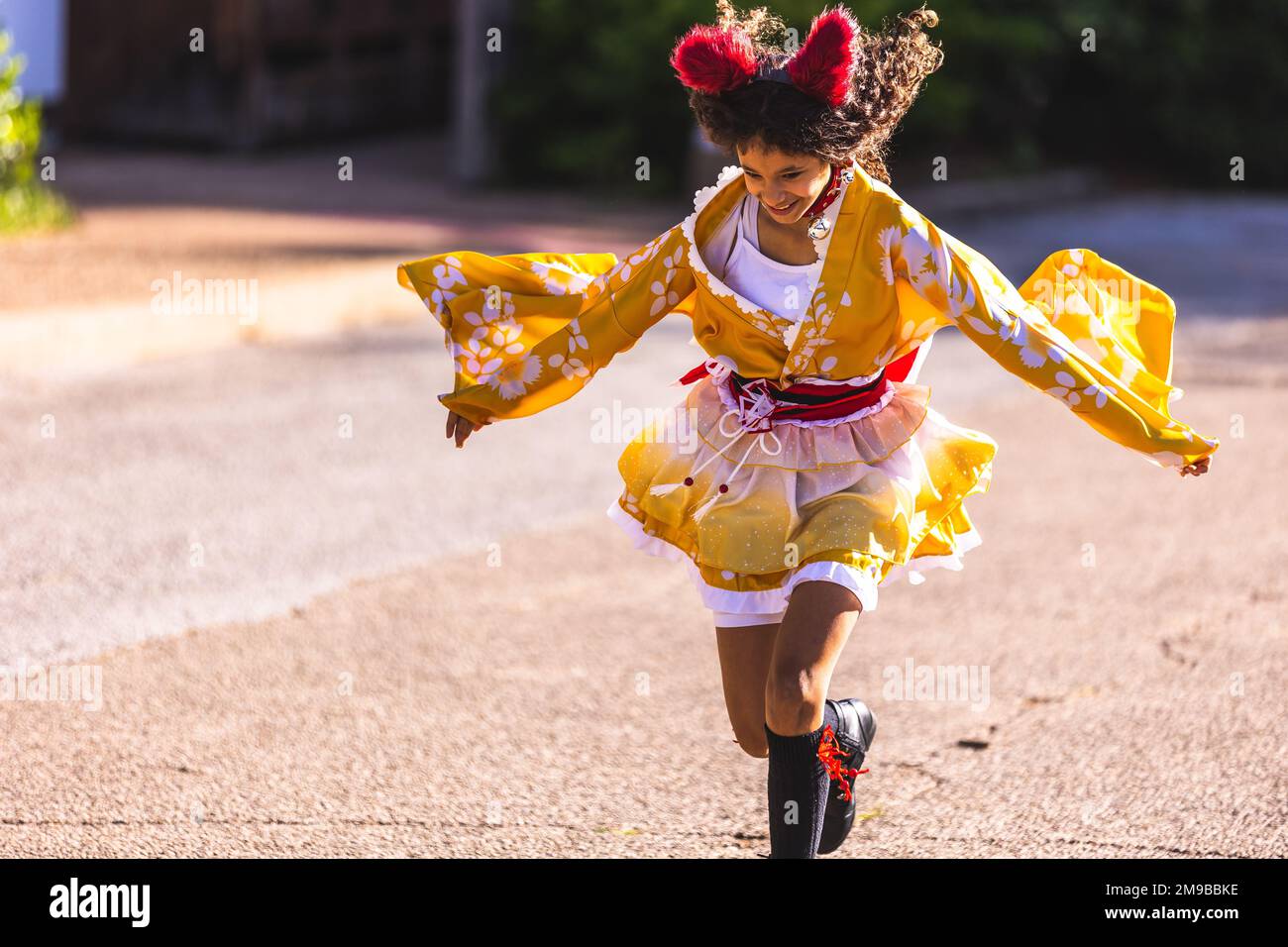 A cute jumping girl kid in the Fort Worth Japanese Gardens at a fall festival Stock Photo