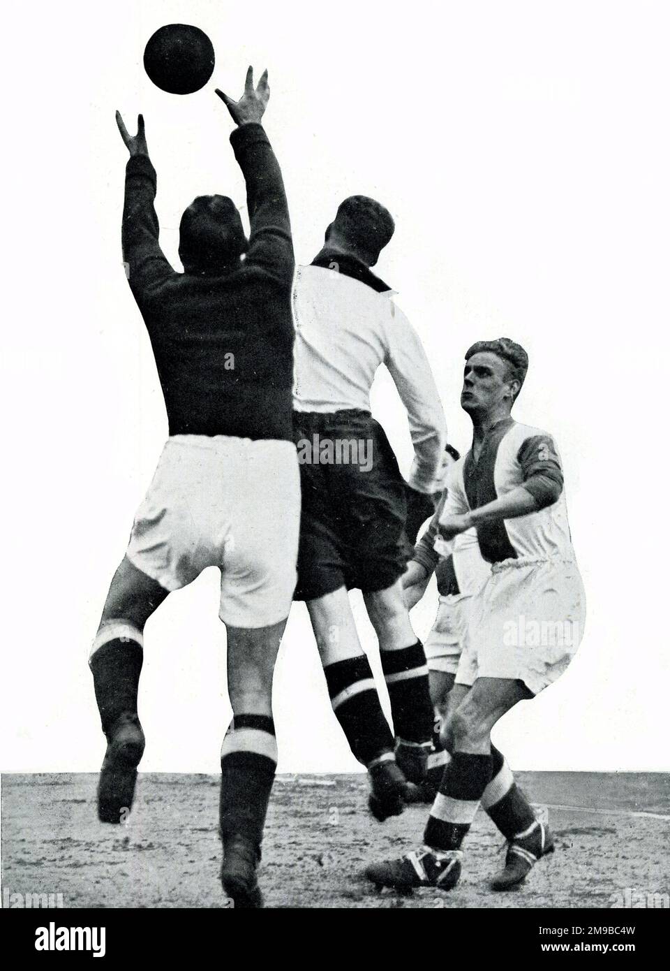 Caunce, Oldham Athletic goalkeeper, clears from Bury forward in Manchester Senior Cup semi-final just before WW2 Stock Photo