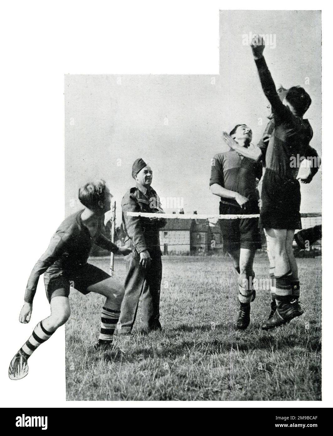 Alex James, in uniform, watches fellow Anti-Aircraft Command members playing football tennis during the Second World War Stock Photo