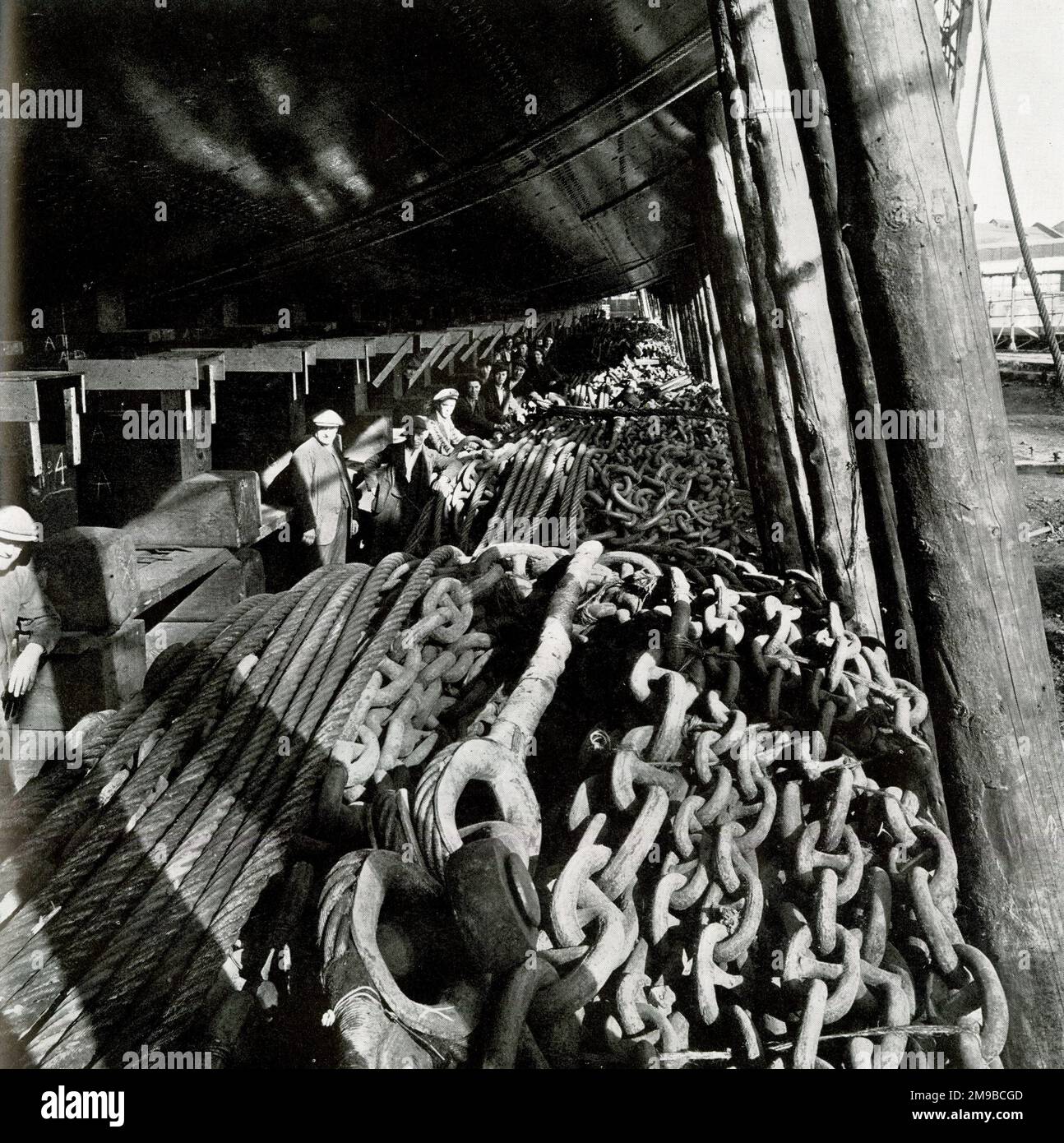 RMS Queen Mary, coils of chains piled under the hull to check progress down the slipway Stock Photo