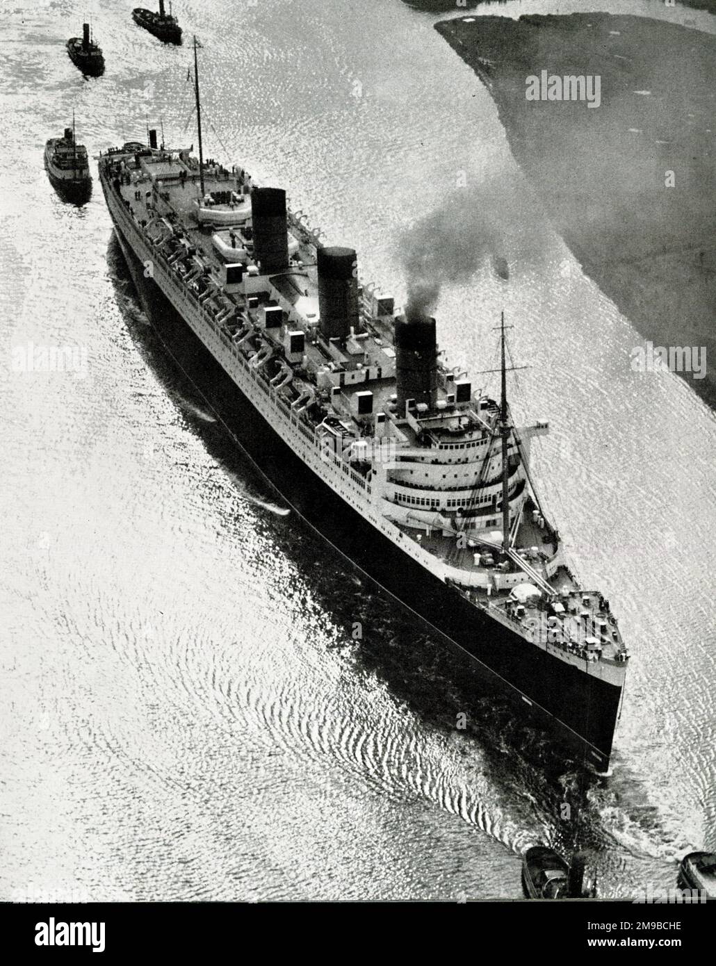 Seven tugs helping to steer RMS Queen Mary down the River Clyde Stock Photo