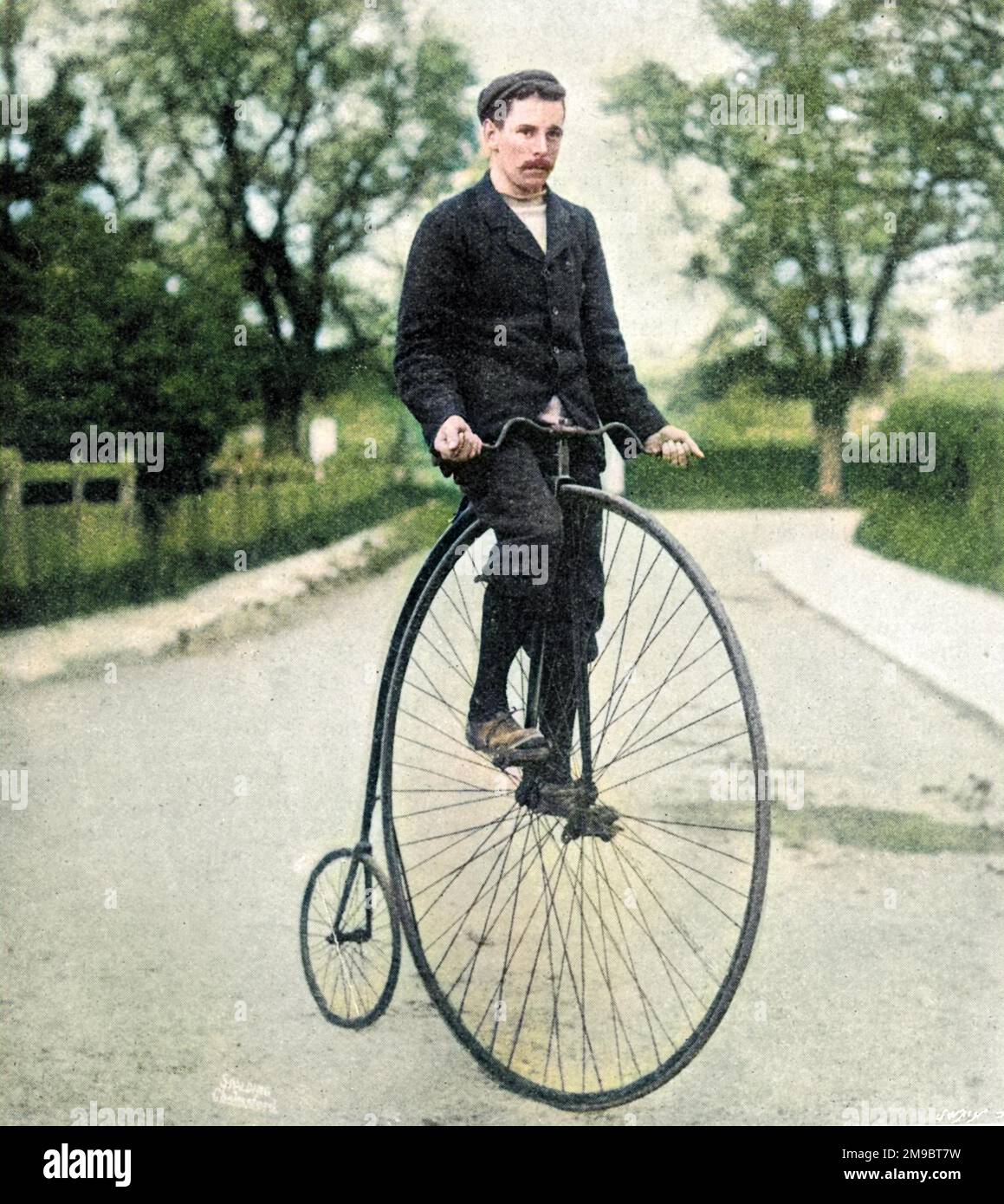 Penny Farthing' or 'Ordinary' bicycle of the 1870s, with its rider wearing contemporary cycling clothes. Stock Photo