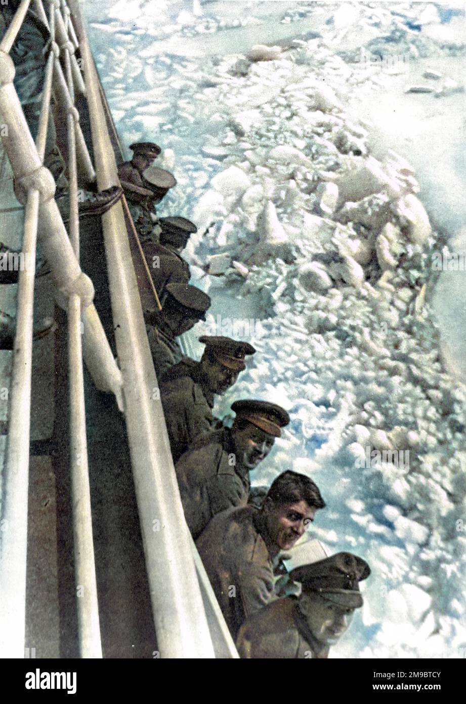 Group of British soldiers leaning over the rail on the deck of a transport ship bound for Russia. On the right of the image one can see the ice that the ship is plowing through. The soldiers were men of a British Armoured-Car detachment. Stock Photo