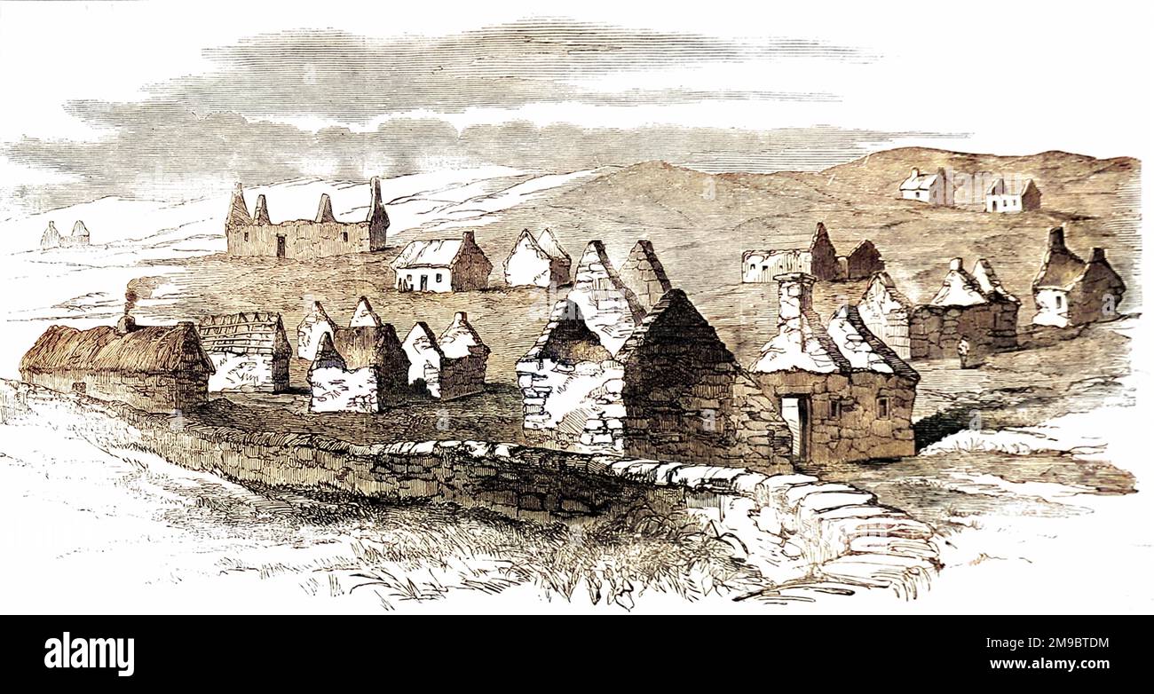 A landscape view of the village of Moveen during the forced evictions of the 1840s. Dwellings, some of them without a roof, appear without human habitation, apart from one with smoke coming out of its chimney. A lone peasant stands next to a roofless cottage building. Stock Photo