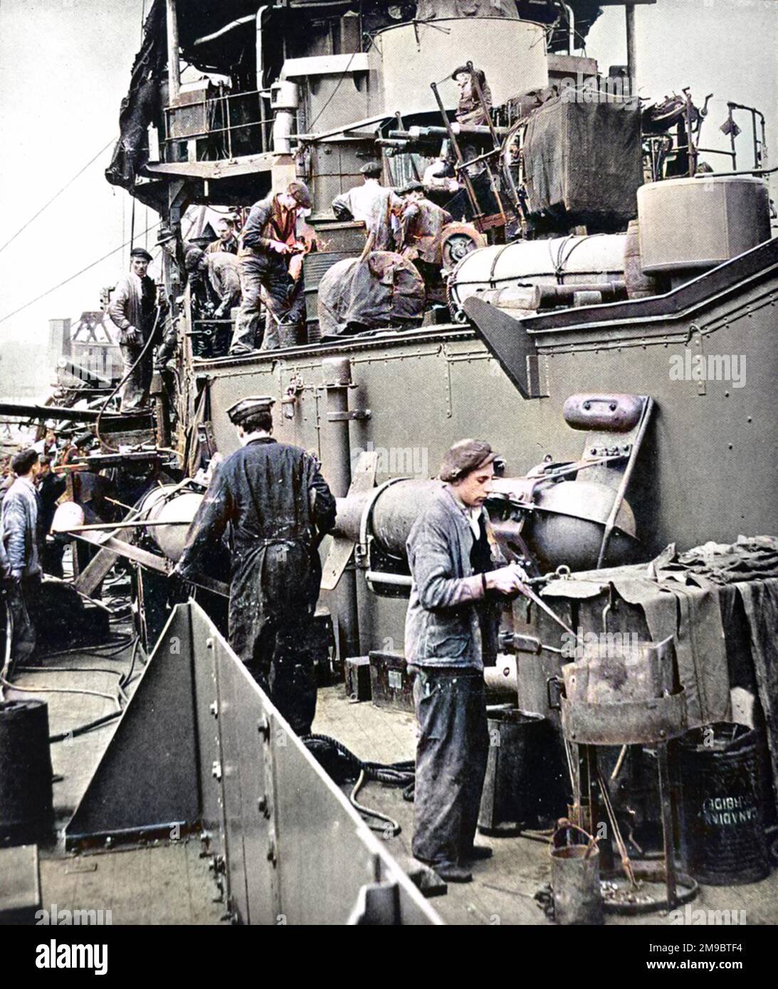 Dockyard workers, including a rivetters' boy working with a portable forge, refitting HMS 'Coventry' during the Second World War, 1940.  HMS 'Coventry' was a Royal Navy anti-aircraft cruiser of 4290 tons. Stock Photo