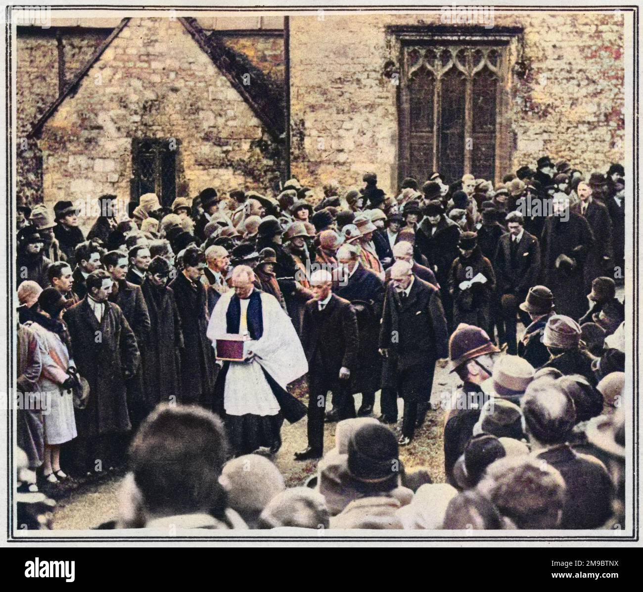 The burial of Thomas Hardy's heart among his own people: the vicar of Stinsford in Dorset ('Mellstock' of 'Under the Greenwood Tree') bearing the casket containing it, with mourners including the novelists brother, from church to grave. Hardy's ashes were interred at Westminster Abbey in Poet's Corner. Stock Photo