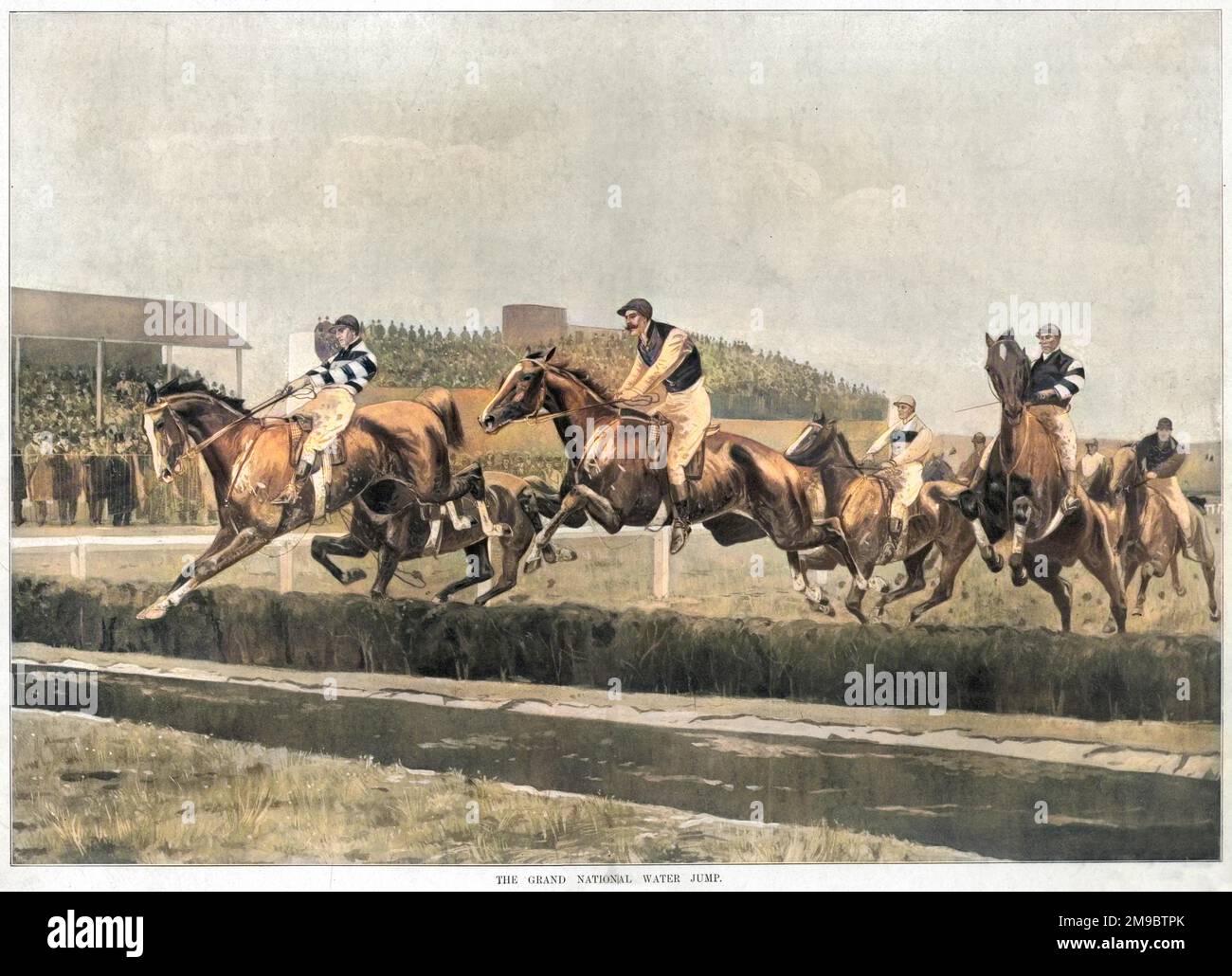 Horses and riders leap over the water jump on the Grand National course