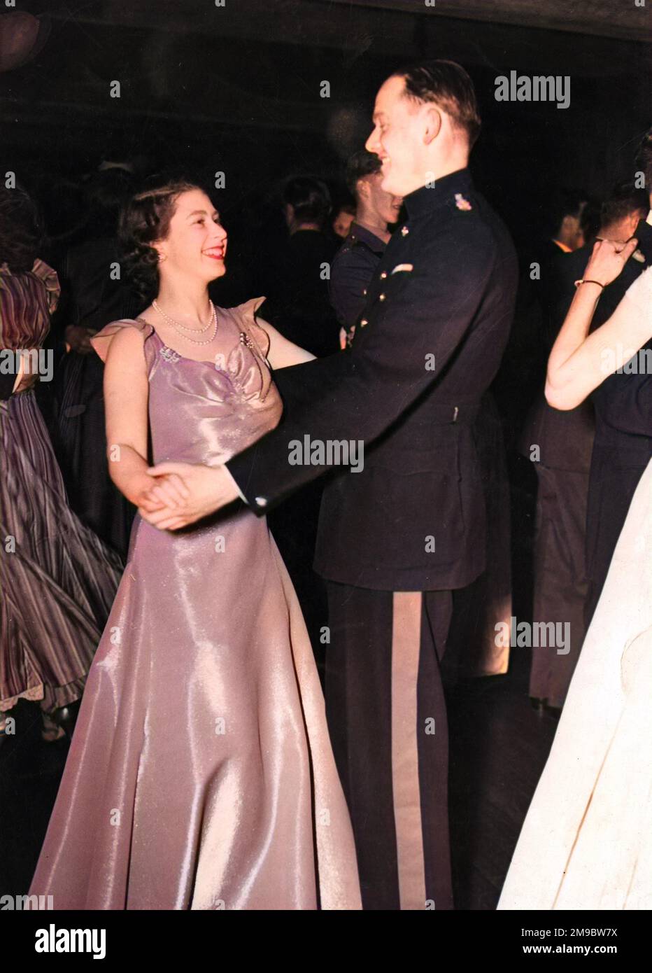Princess Elizabeth (Queen Elizabeth II) attending a ball held at the Old House Hotel in aid of the NSPCC.  She is pictured smiling as she dances with Captain Joshua Rayley of the Grenadier Guards. Stock Photo