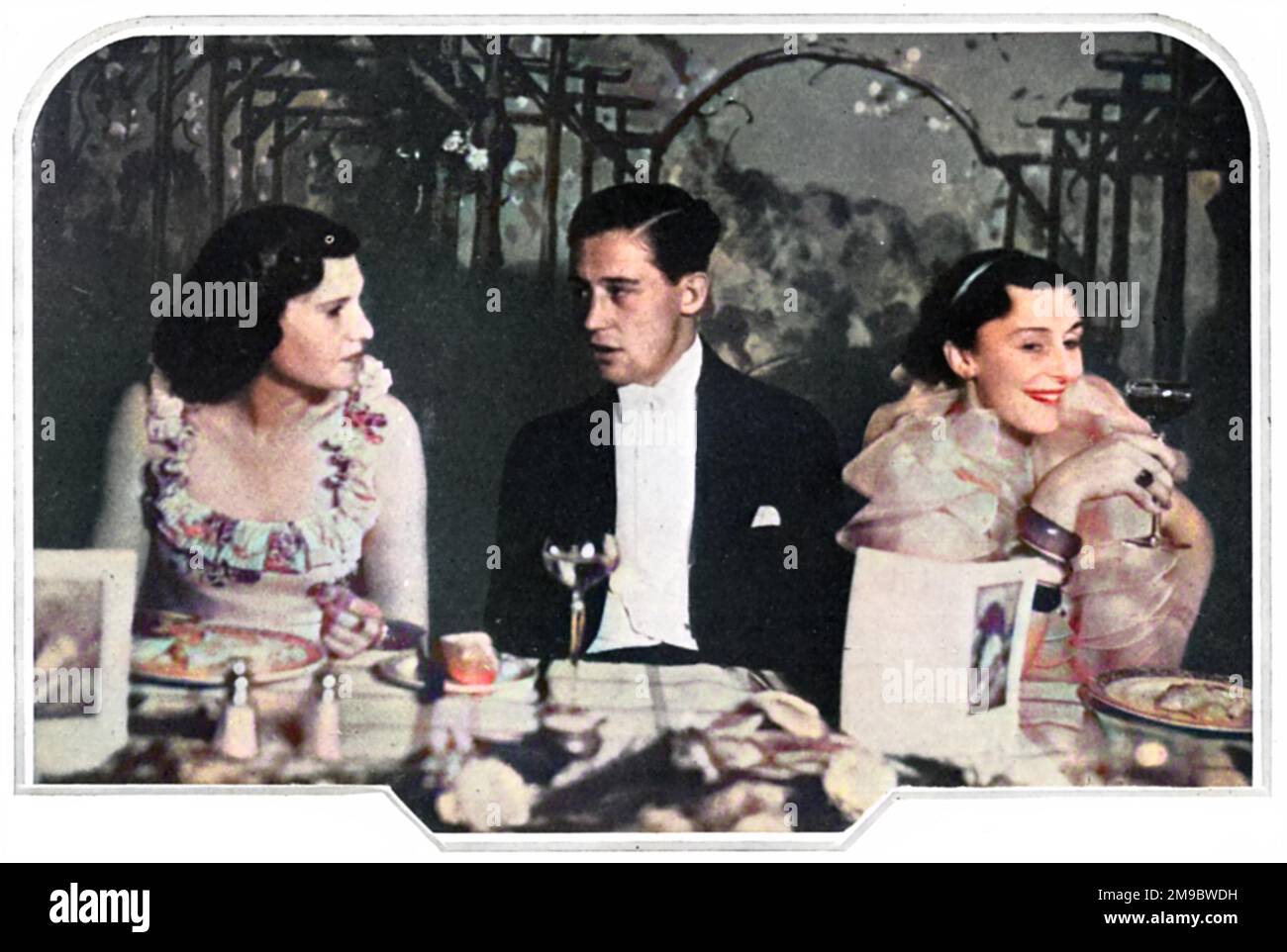 Roger Bushell at a dinner to celebrate the foundation of the Vintage Club, established to teach people to appreciate fine wine. To the left is Miss Livia Paravicini and to the right Miss Violet Voules. Bushell would later join the RAF and following capture in 1940, later became the mastermind behind the 'Great Escape' attempt from Stalag Luft III at Sagan. Stock Photo