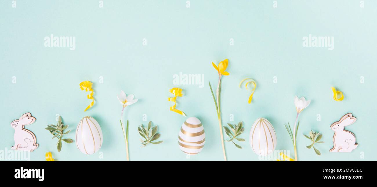 Festive Easter border, frame from easter eggs and spring flower crocus on blue background. Stock Photo
