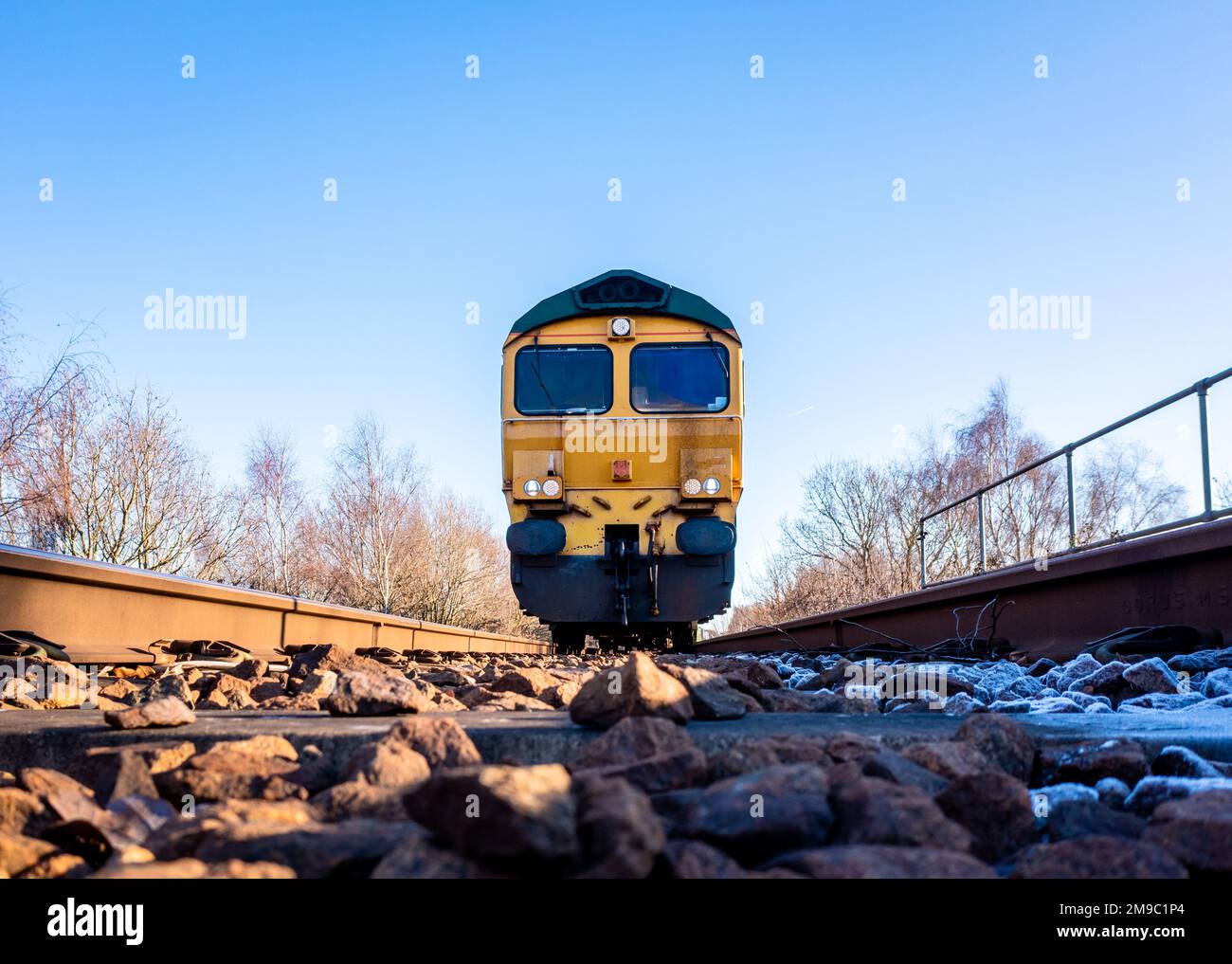 A point of view image of the front of a freight locomotive moving towards a person on the railway line in a suicide or occupational safety concept Stock Photo