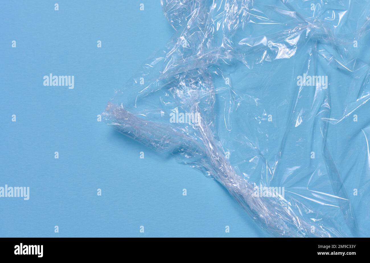 Crumpled transparent polyethylene on a blue background, top view Stock Photo