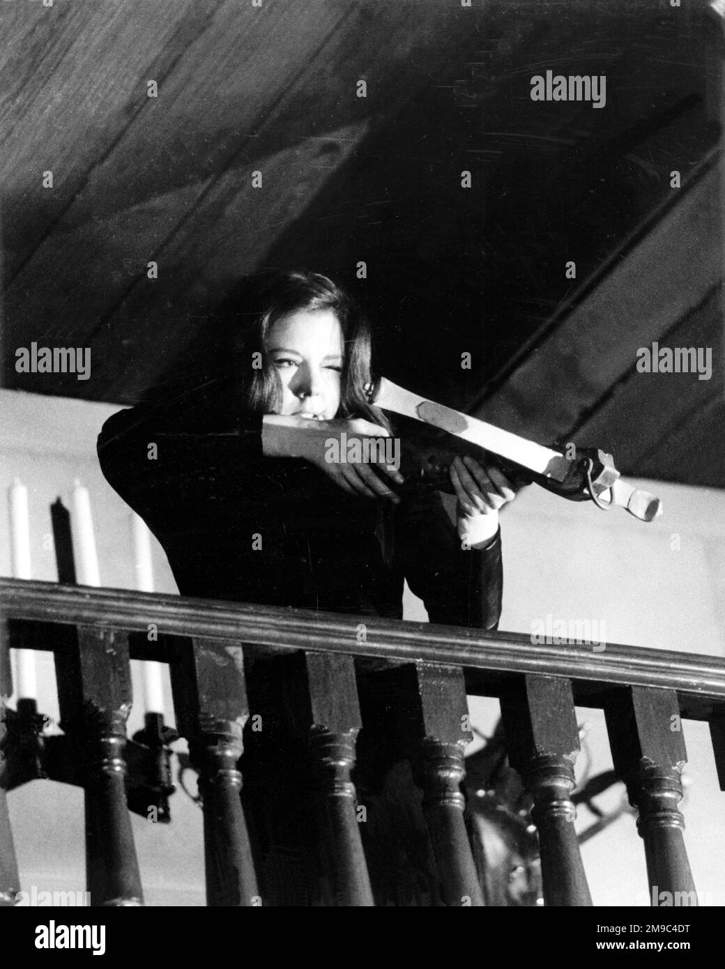 Emma Peel of 'The Avengers', played by Diana Rigg, firing a crossbow during filming of an episode Stock Photo