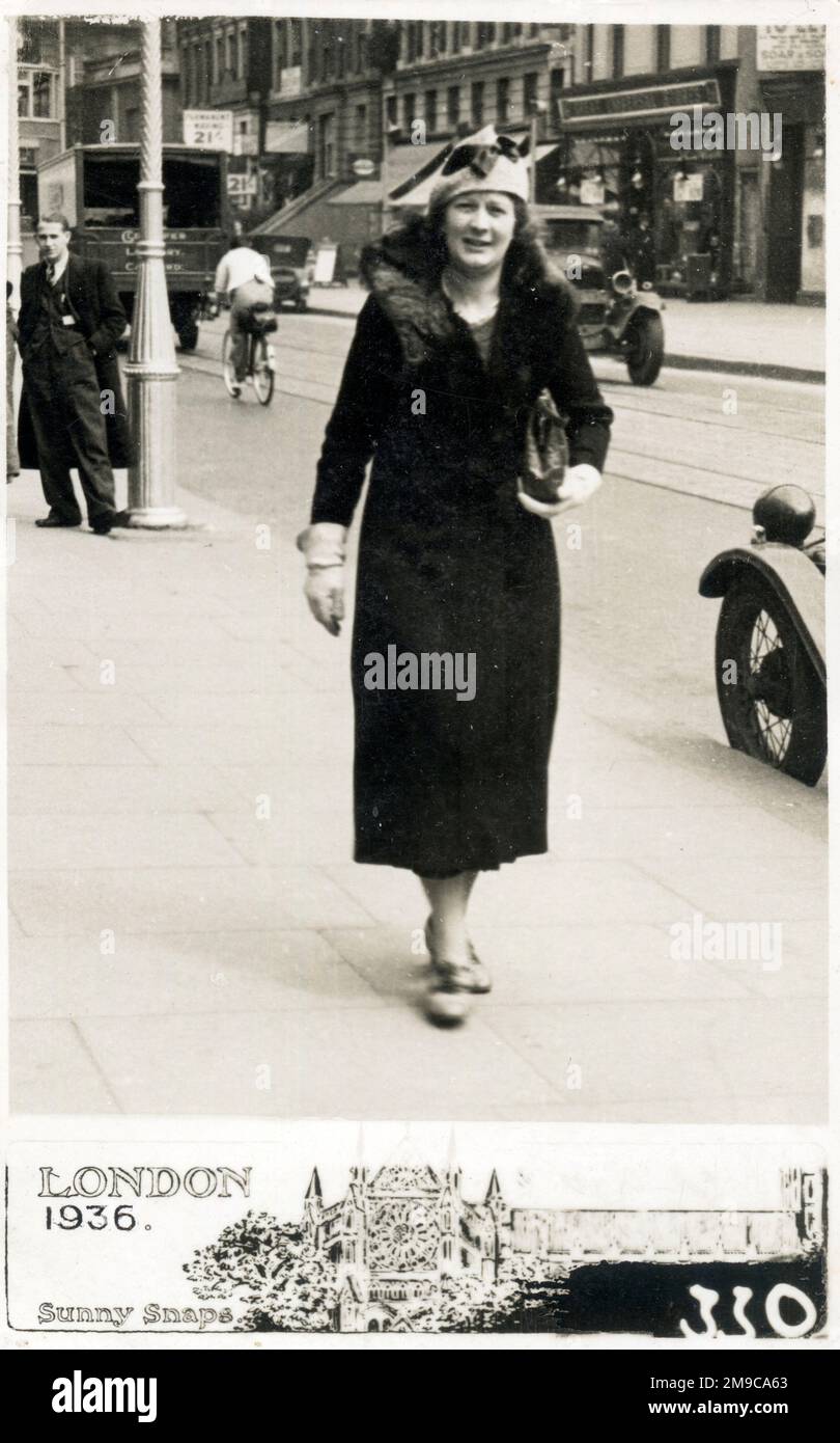 Sunny Snaps Candid 'Walking' Postcard from London - A middle aged woman in long fur-trimmed coat in Lewisham, South East London, May 1936. Stock Photo