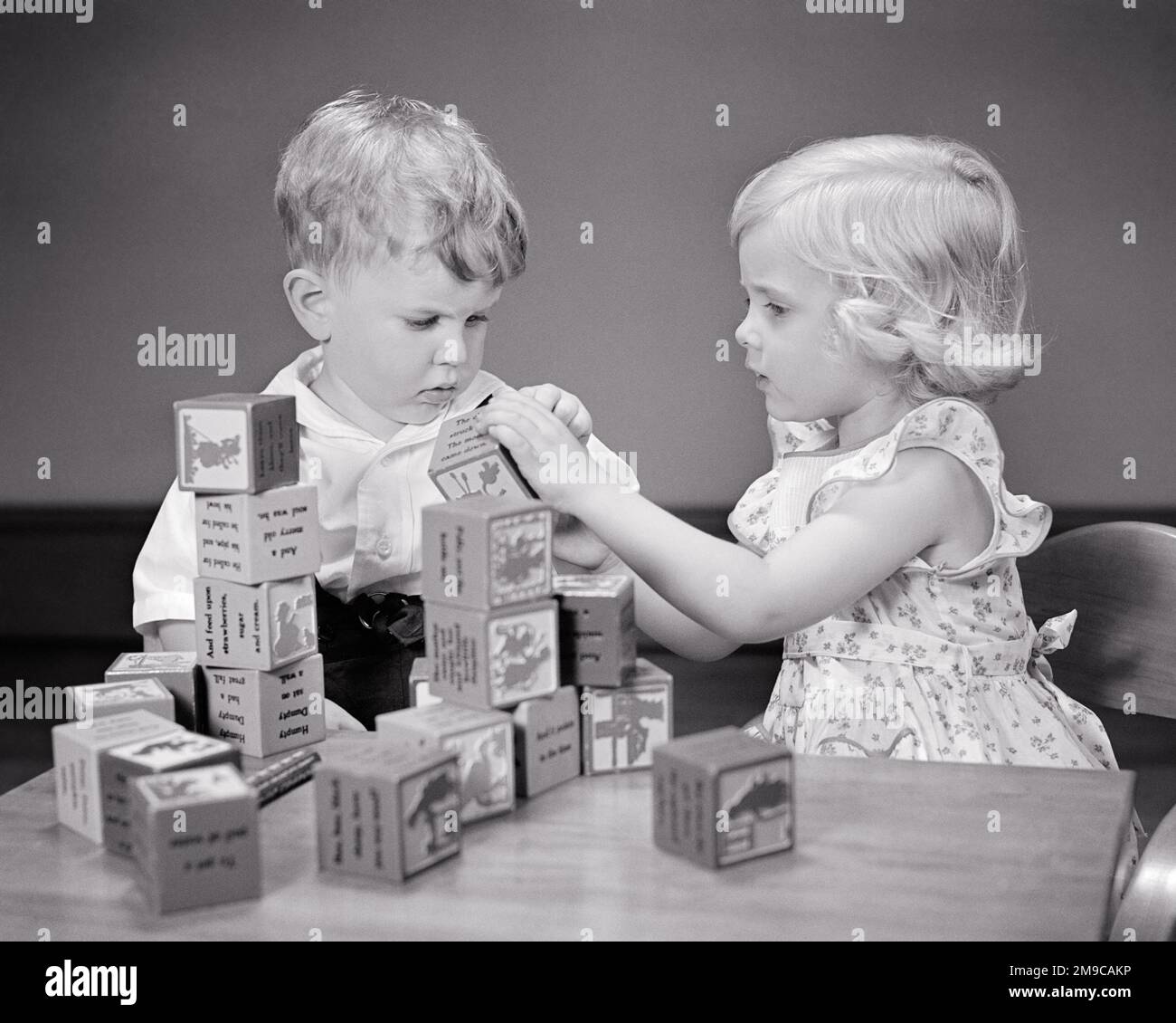 1940s LITTLE BLOND BOY AND GIRL BROTHER AND SISTER SHARING PLAYING TOGETHER WITH CREATIVE WOODEN BUILDING BLOCKS - j10492 HAR001 HARS FEMALES BROTHERS STUDIO SHOT HOME LIFE FRIENDSHIP HALF-LENGTH INSPIRATION CARING MALES SIBLINGS CONFIDENCE SISTERS B&W SUCCESS HAPPINESS DISCOVERY STRENGTH NETWORKING CHOICE LEADERSHIP POWERFUL RECREATION PRIDE SIBLING CONCEPTUAL IMAGINATION STYLISH COOPERATION CREATIVITY GROWTH JUVENILES PRECISION TOGETHERNESS BLACK AND WHITE CAUCASIAN ETHNICITY HAR001 OLD FASHIONED Stock Photo