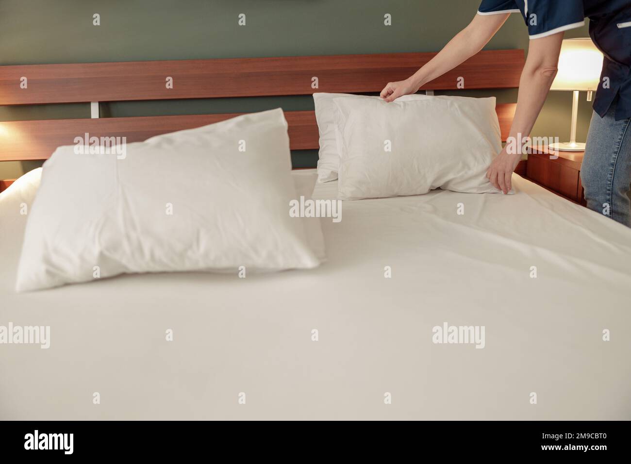 Cleaning lady doing housekeeping and making bed in hotel room. Cleaning service concept Stock