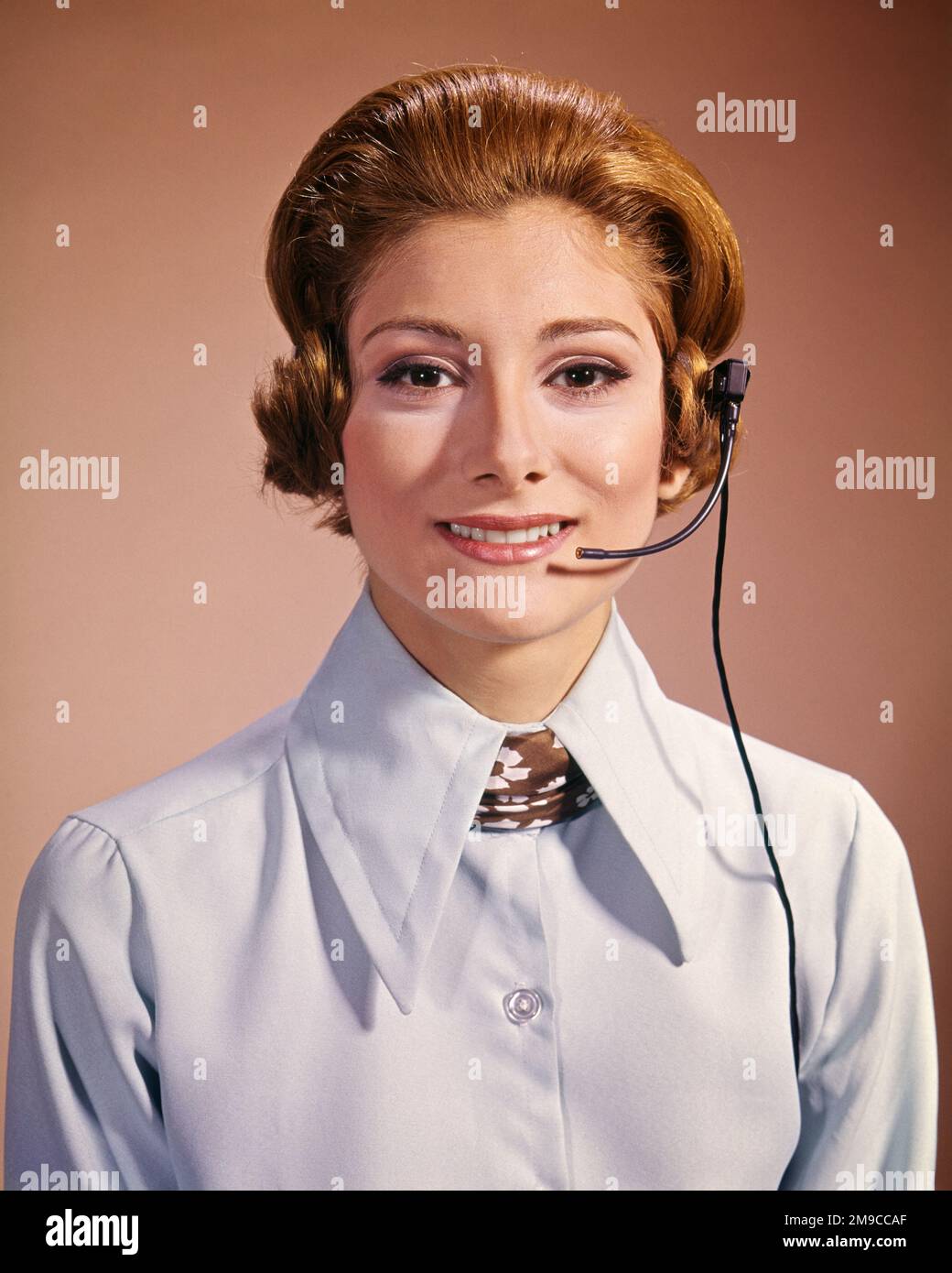1960s 1970s SMILING WOMAN WEARING TELEPHONE HEADSET OFFICE RECEPTIONIST CALL CENTER SALESPERSON LOOKING AT CAMERA - kg3449 HAR001 HARS STYLE COMMUNICATION CENTER INFORMATION PLEASED JOY LIFESTYLE SALESPERSON CALL FEMALES JOBS STUDIO SHOT COMMUNICATING COPY SPACE LADIES PERSONS CONFIDENCE HEADSET EYE CONTACT SKILL OCCUPATION SELLING SKILLS OPERATOR HEAD AND SHOULDERS CHEERFUL LEADERSHIP REDHEAD PRIDE SUPERVISOR OCCUPATIONS PHONES SMILES RED HAIR TELEPHONES JOYFUL SALESWOMAN SALESWOMEN STYLISH CALM COOPERATION MID-ADULT MID-ADULT WOMAN CAUCASIAN ETHNICITY HAR001 OLD FASHIONED Stock Photo
