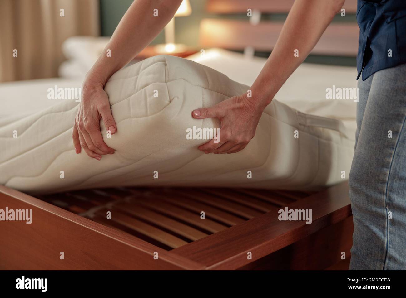Close up of cleaning lady doing housekeeping and making bed in hotel